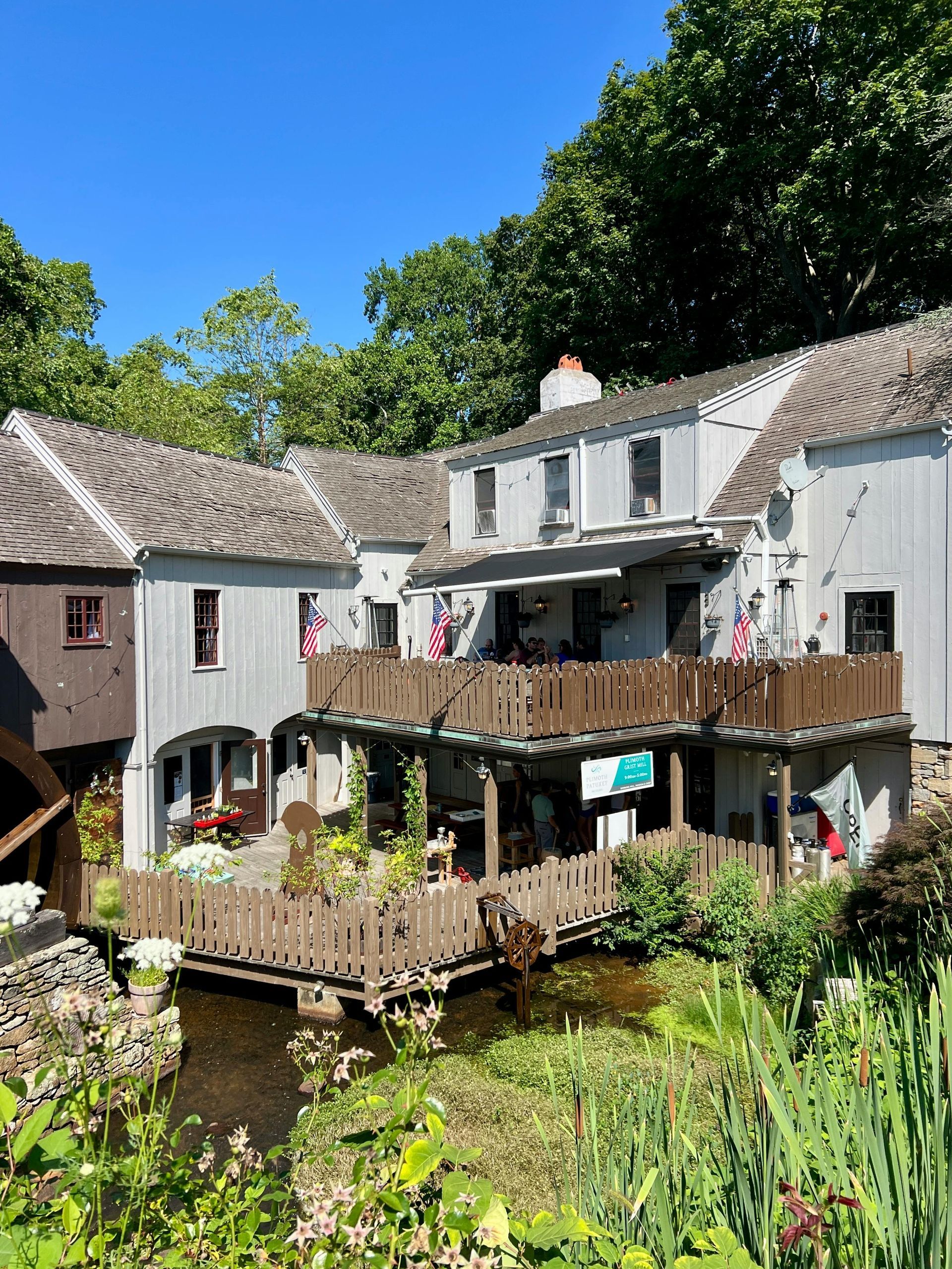 A roof with a vent on it and a building in the background.