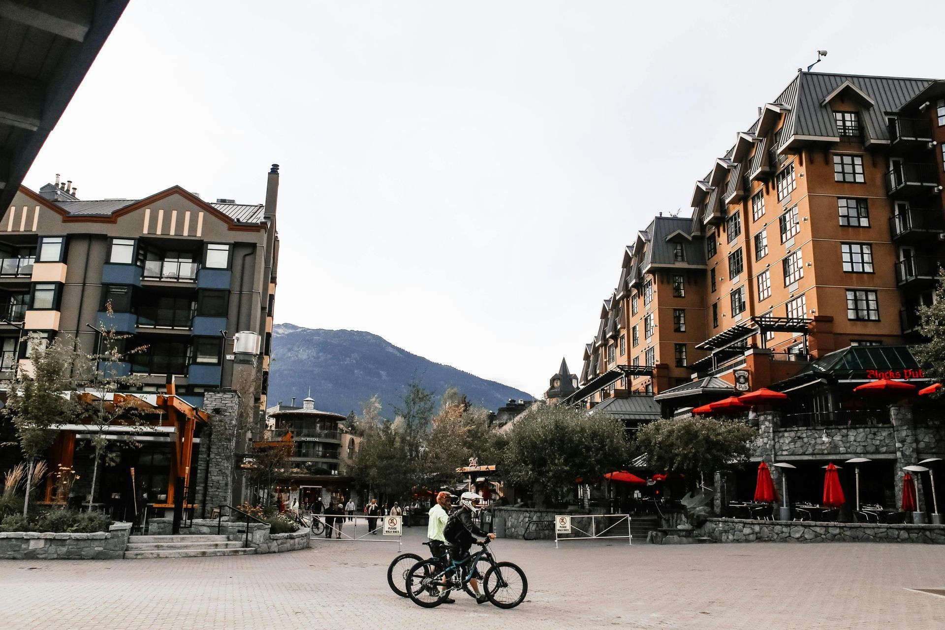 A couple riding bicycles in front of a building, roofing whistler, vancouver roofing