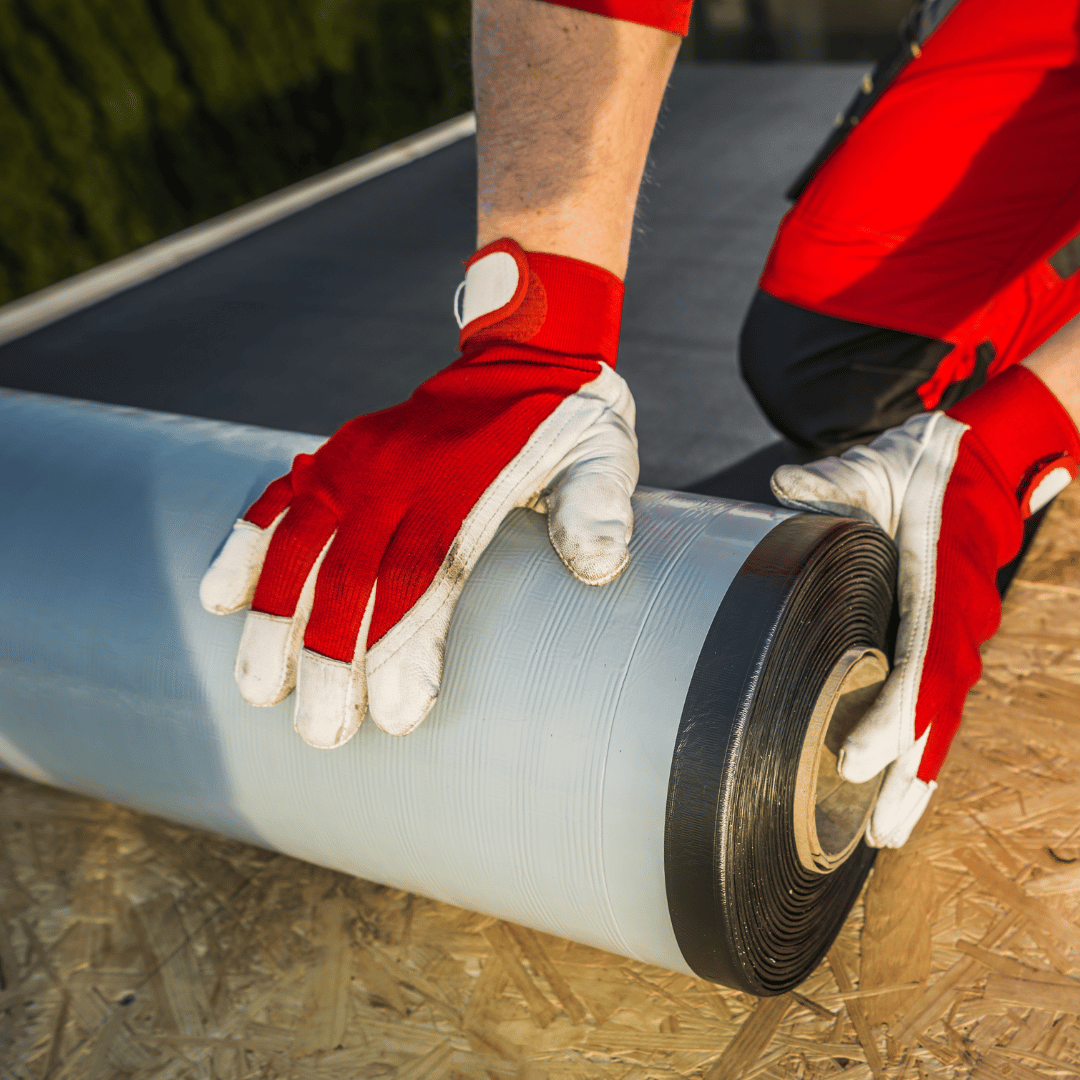 A person wearing red and white gloves is holding a roll of tape.