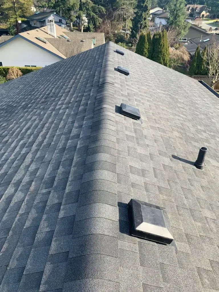 A roof with a lot of shingles and a lot of vents on it.
