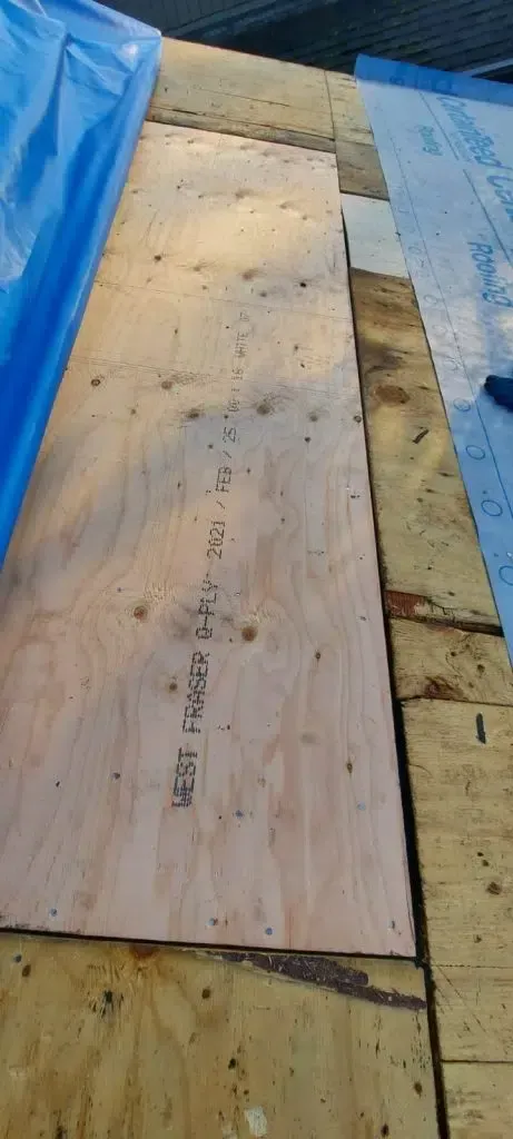 A piece of plywood is sitting on top of a roof.
