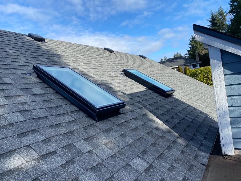 There are two skylights on the roof of a house as delta roofing company, delta roofing