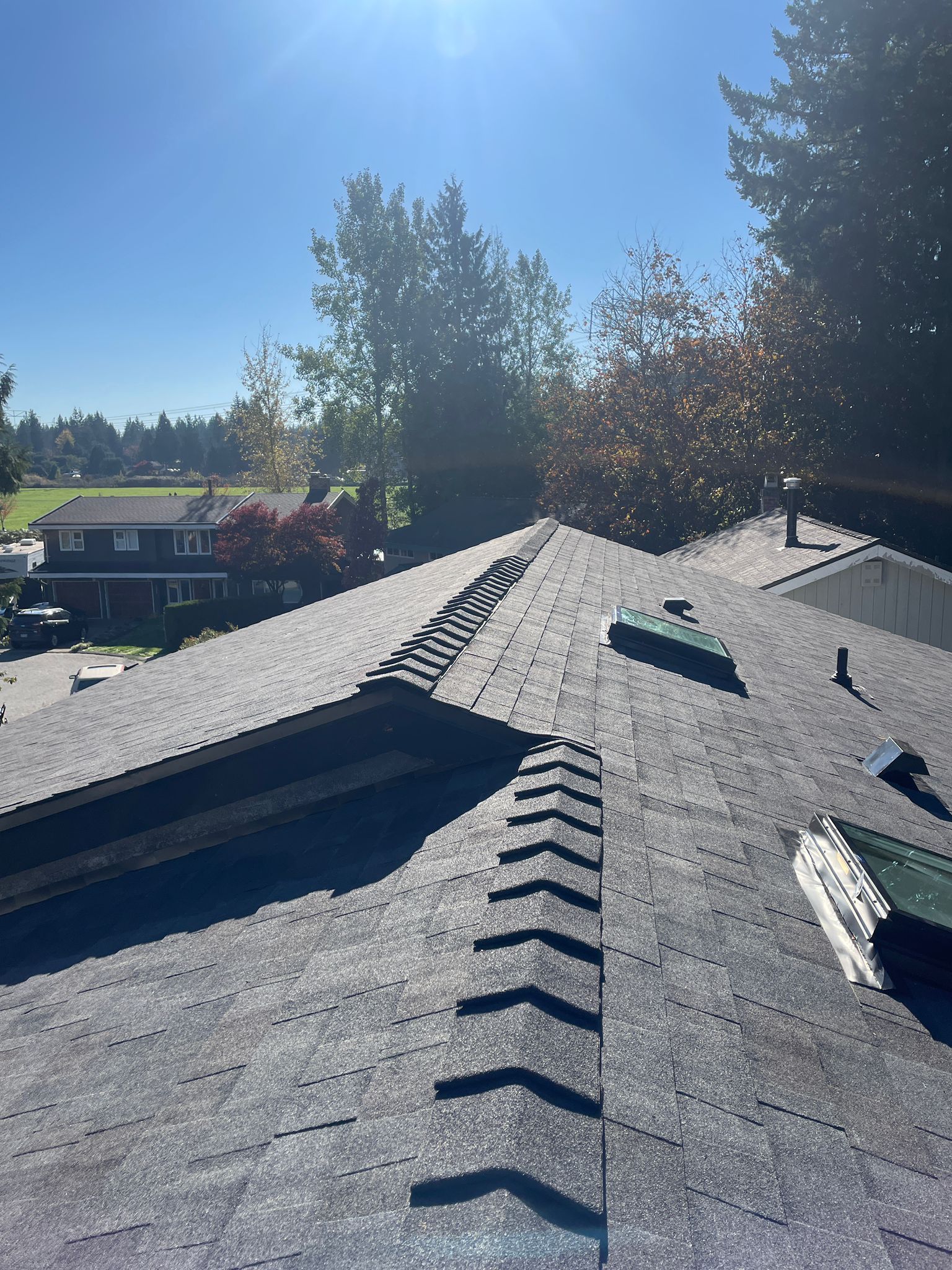 A roof with a row of arrows on it and a house in the background.