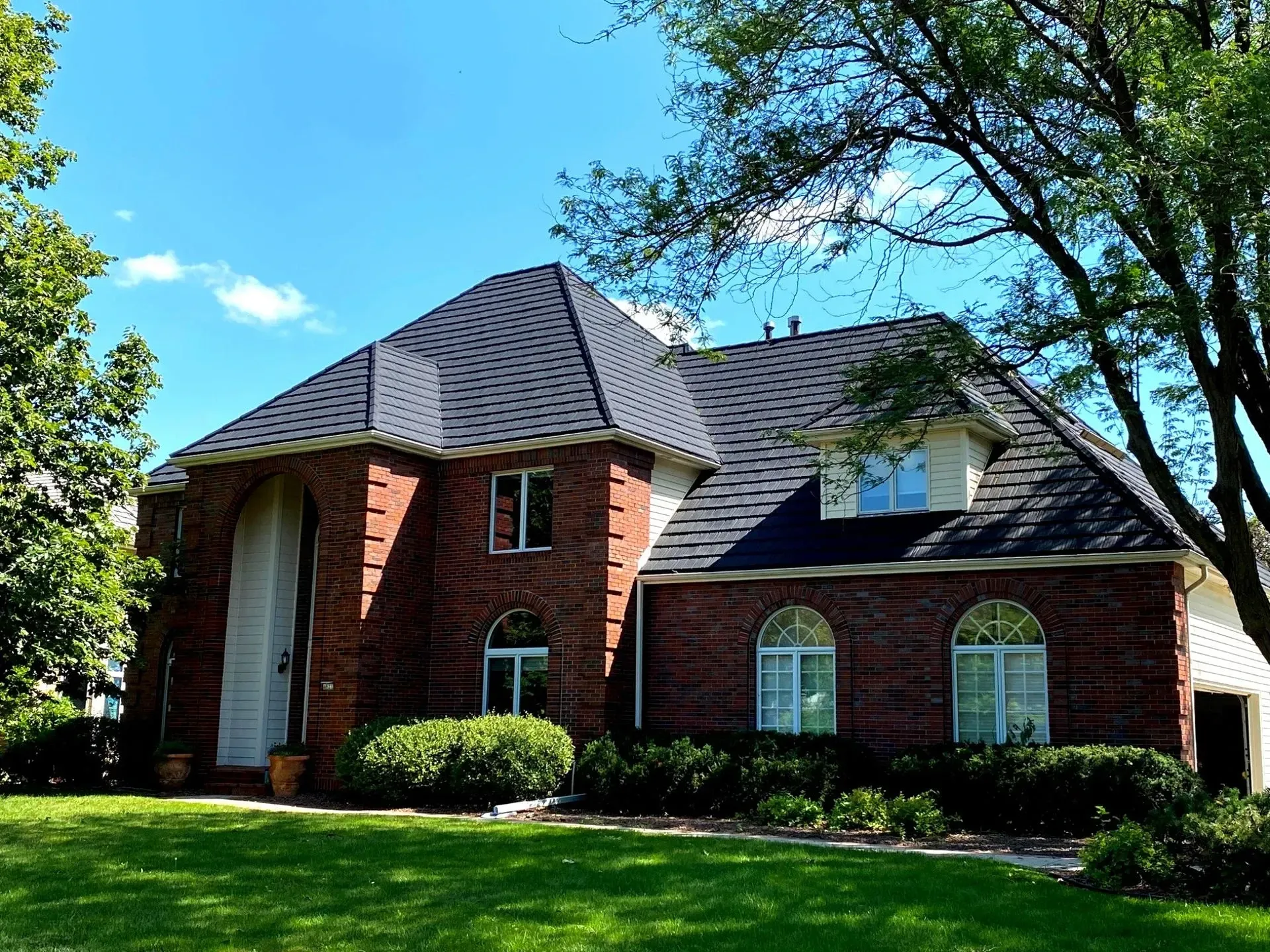 A roof with a vent on it and a building in the background.