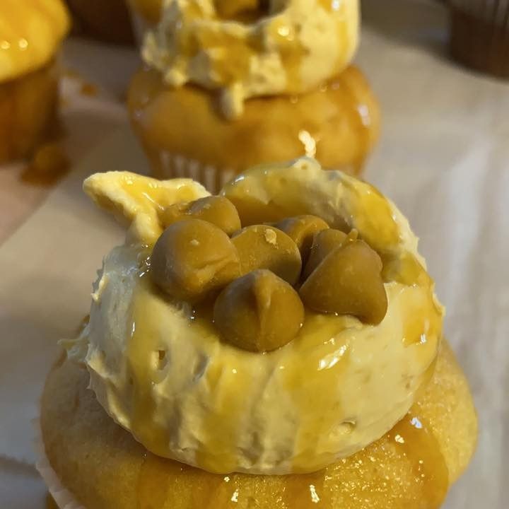 Cupcakes topped with creamy frosting, caramel drizzle, and butterscotch chips.