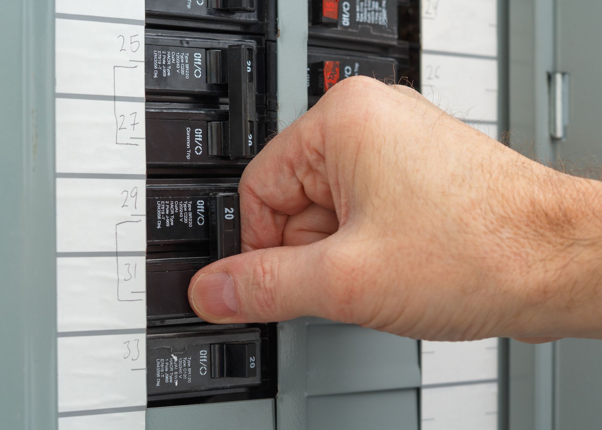 A woman is holding a candle in front of an electrical box.