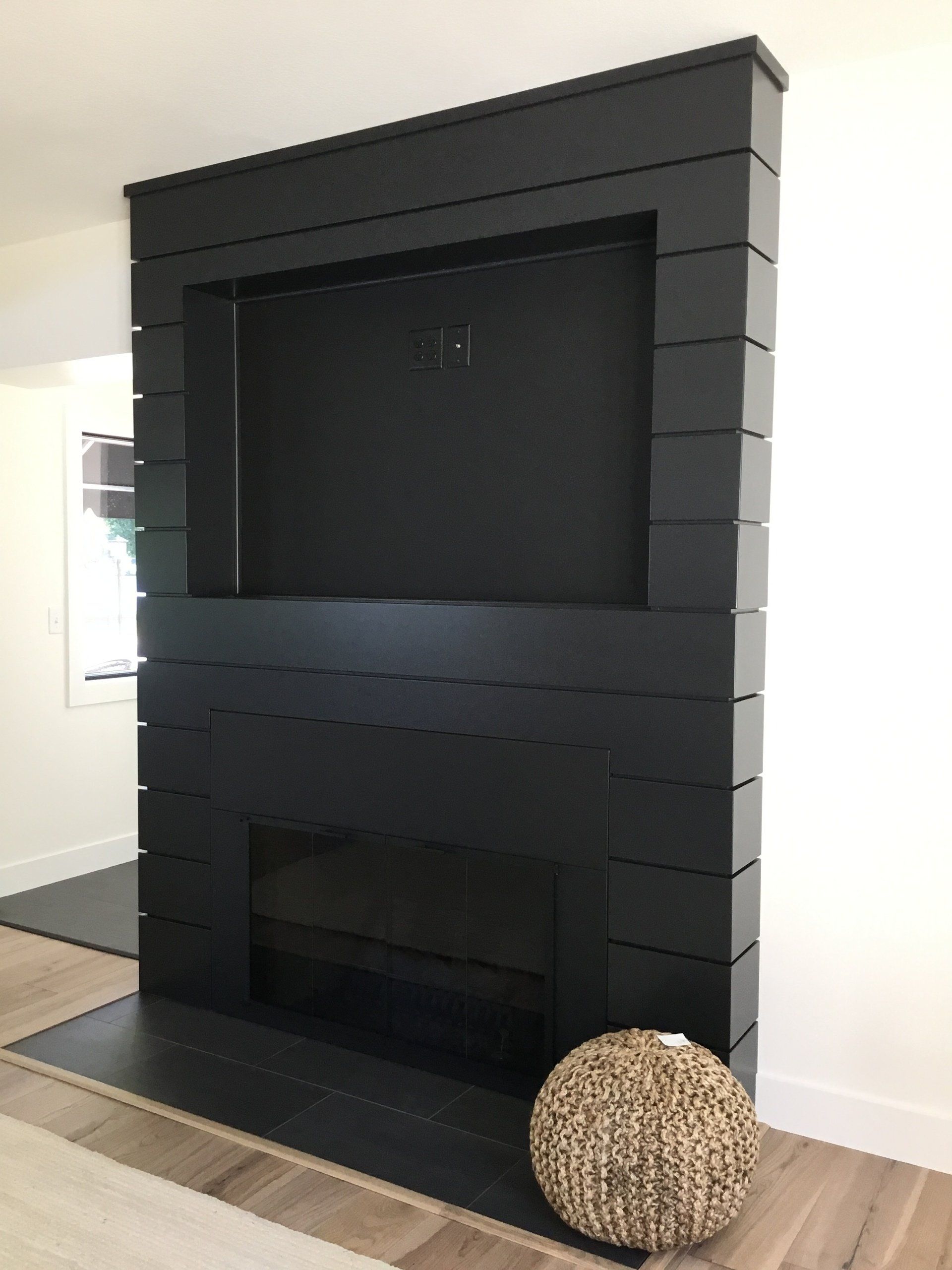 A living room with a fireplace and a flat screen tv on the wall.