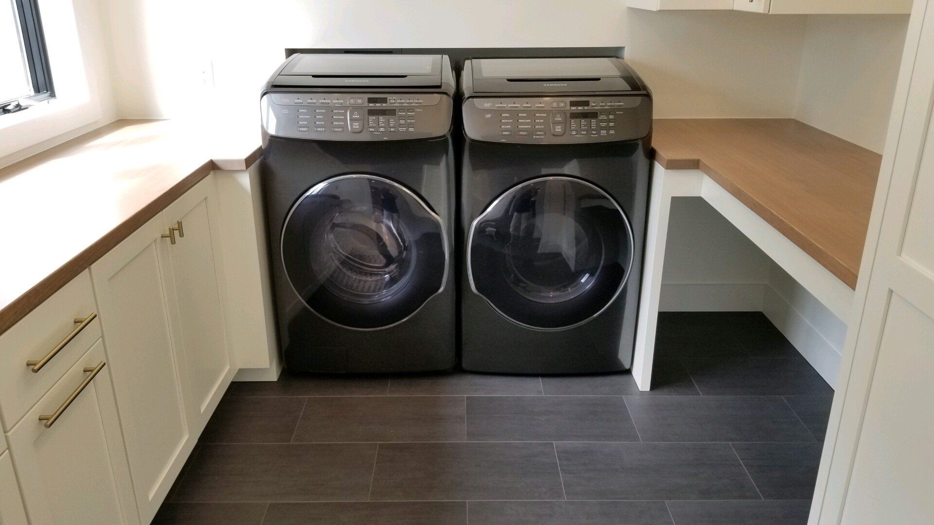 There are two washers and dryers in the laundry room.