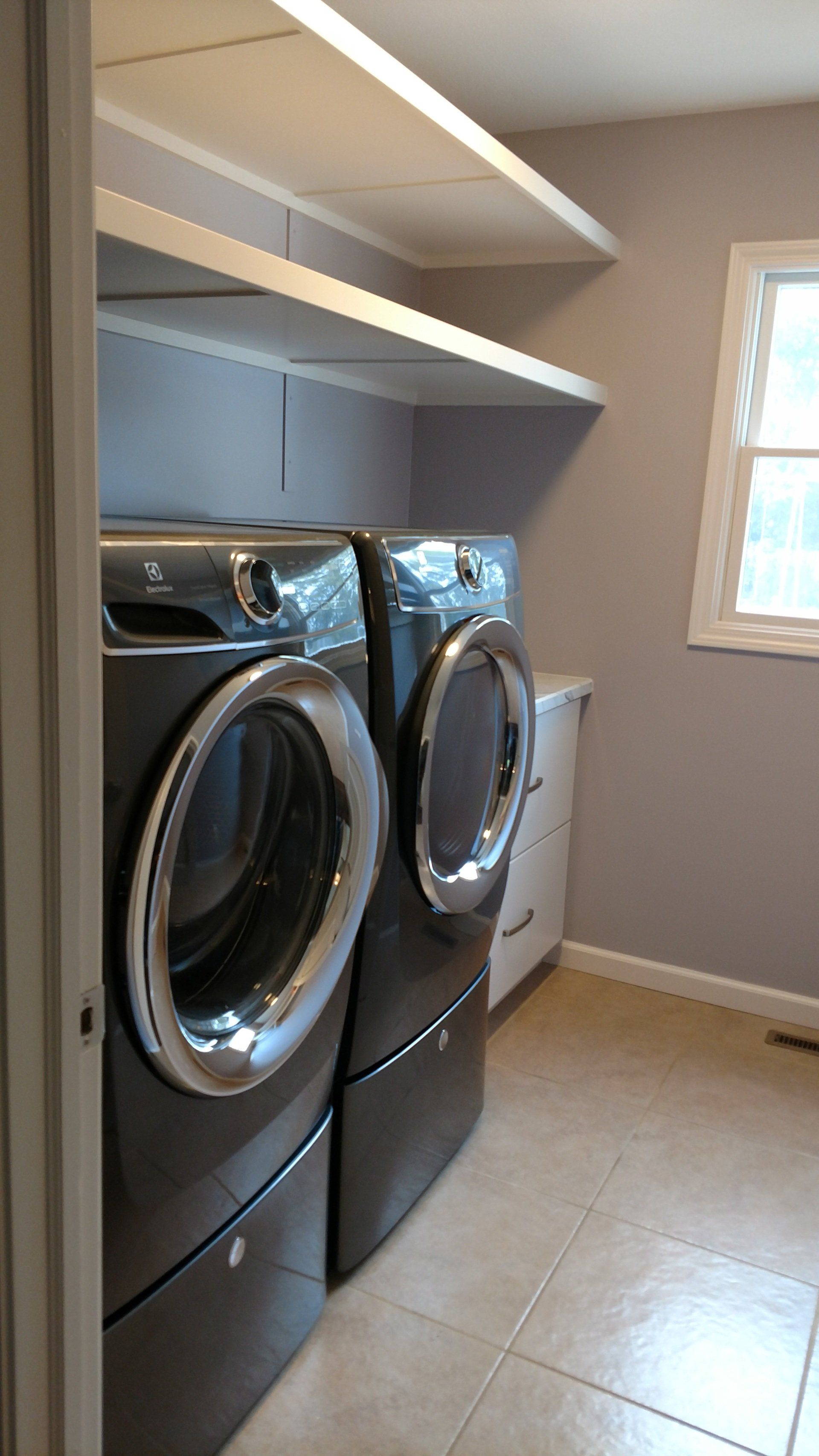 A laundry room with a washer and dryer and a window.