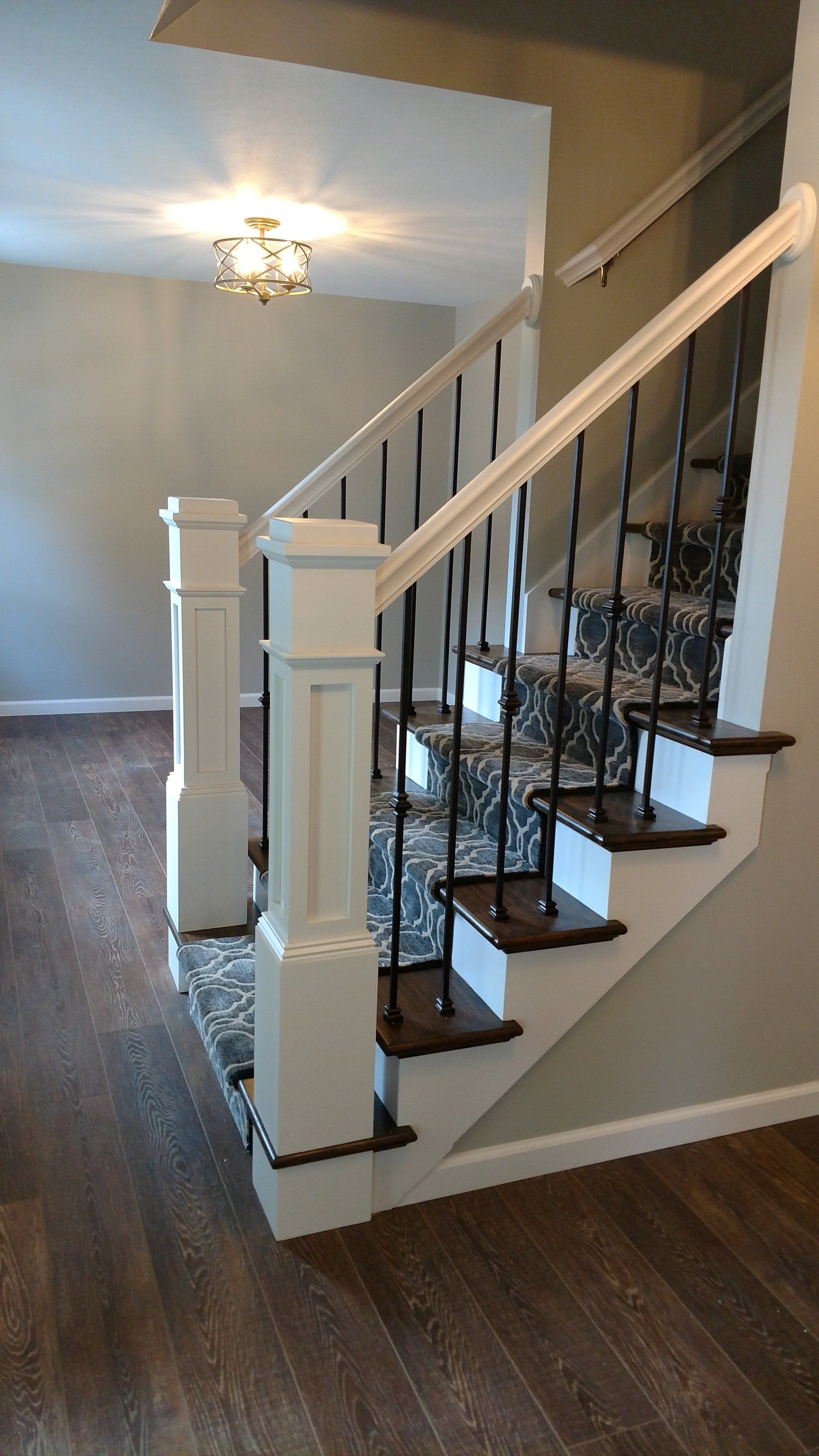 A white staircase with a black railing in a house.