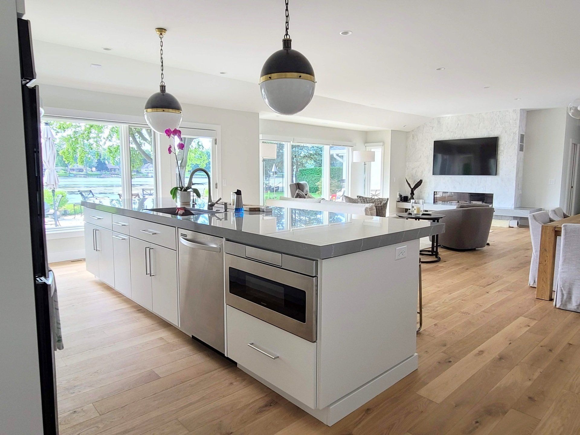 A kitchen with white cabinets and stools and a large island