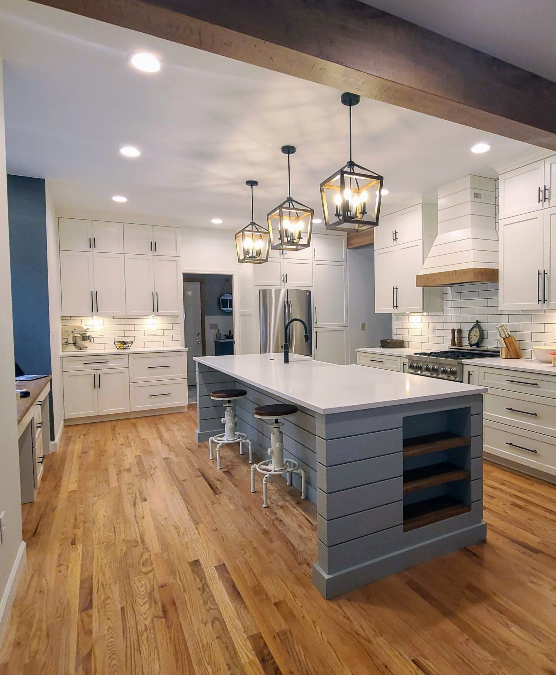 A kitchen with a large island and wooden floors