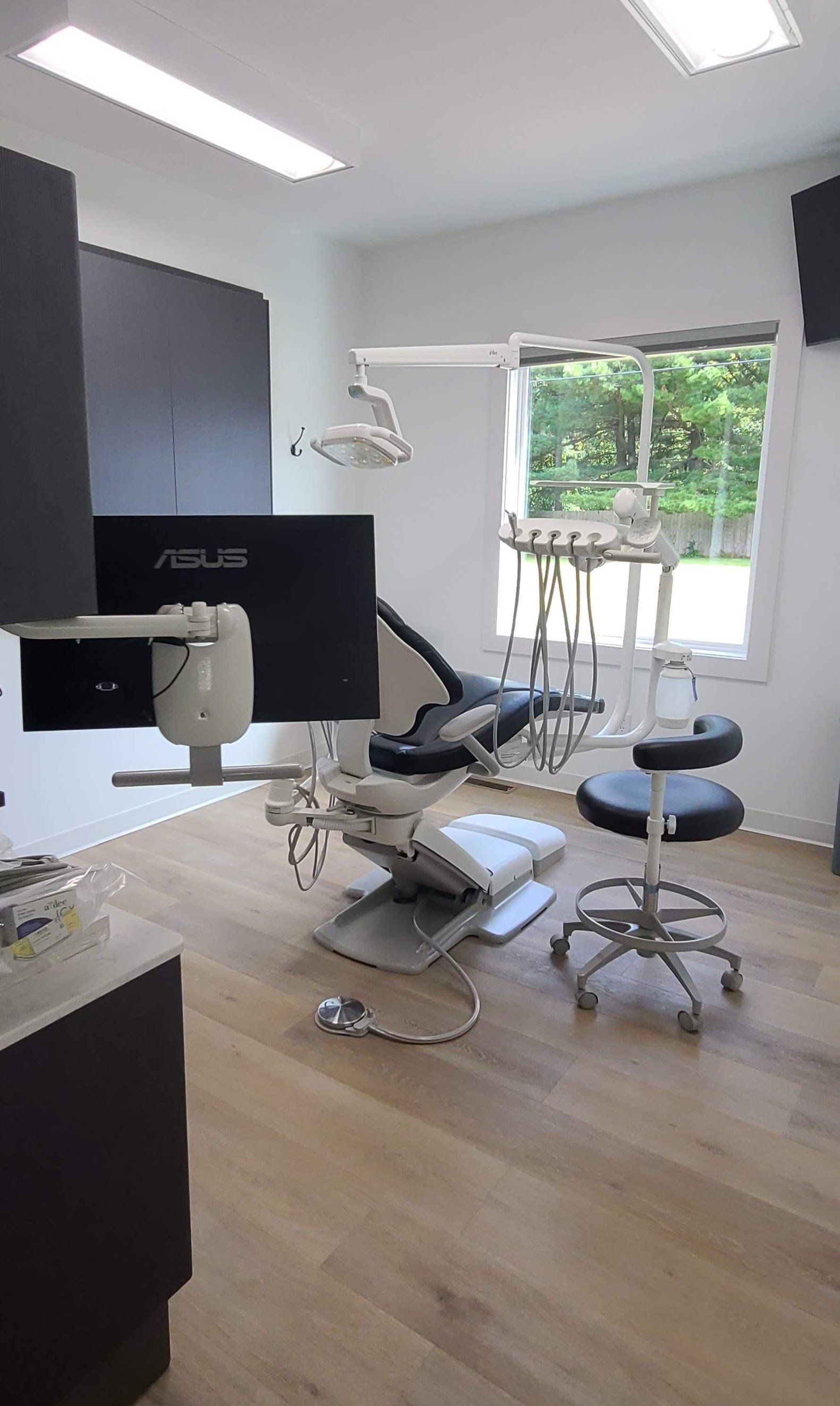 A dental office with a dental chair and a monitor.