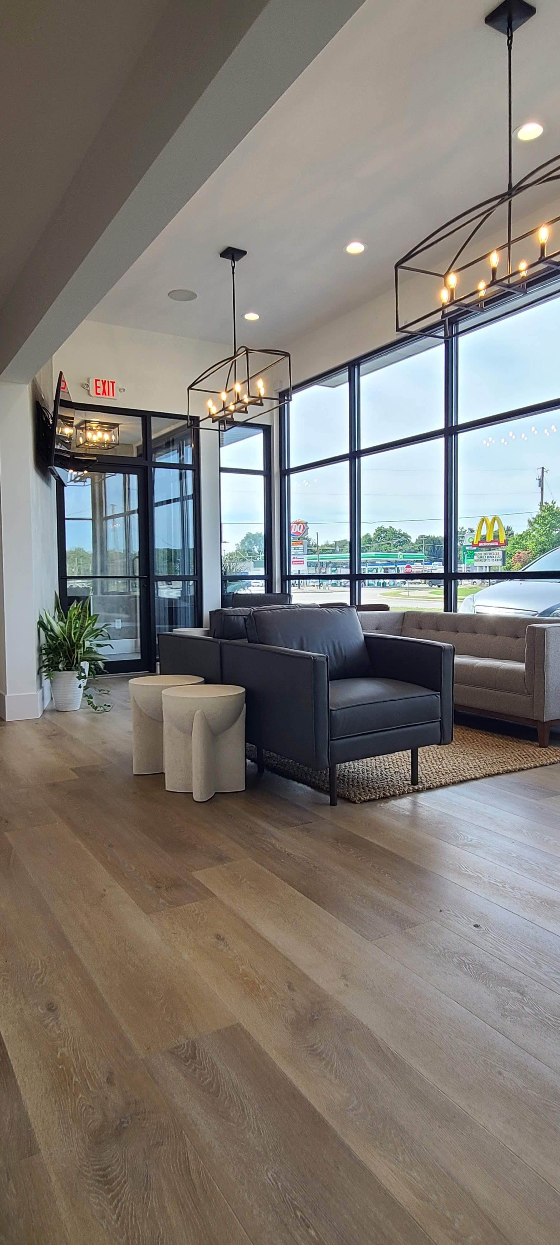 A living room with a lot of windows and chairs.