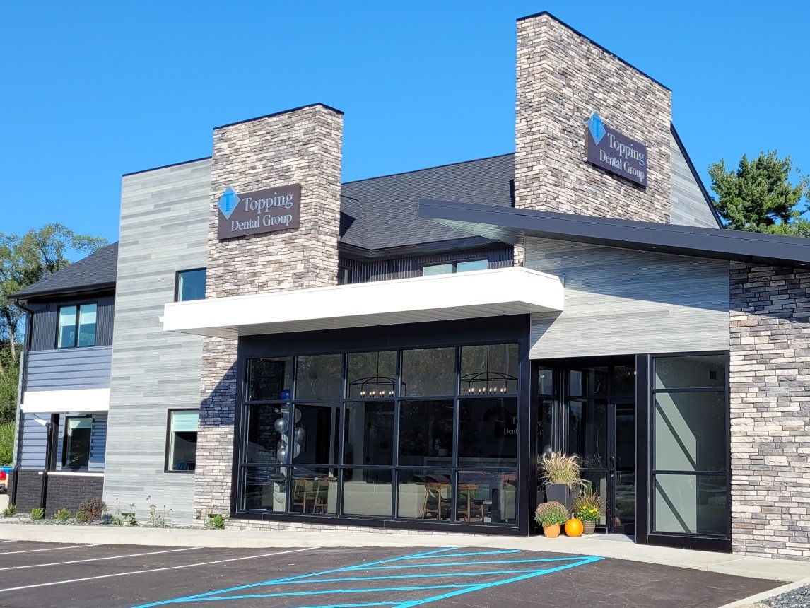 A large building with a lot of windows and a handicapped parking spot in front of it.