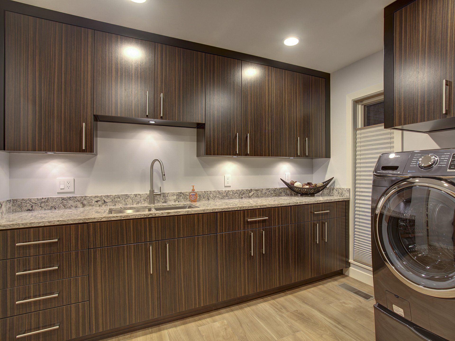 A kitchen with wooden cabinets and a washer and dryer