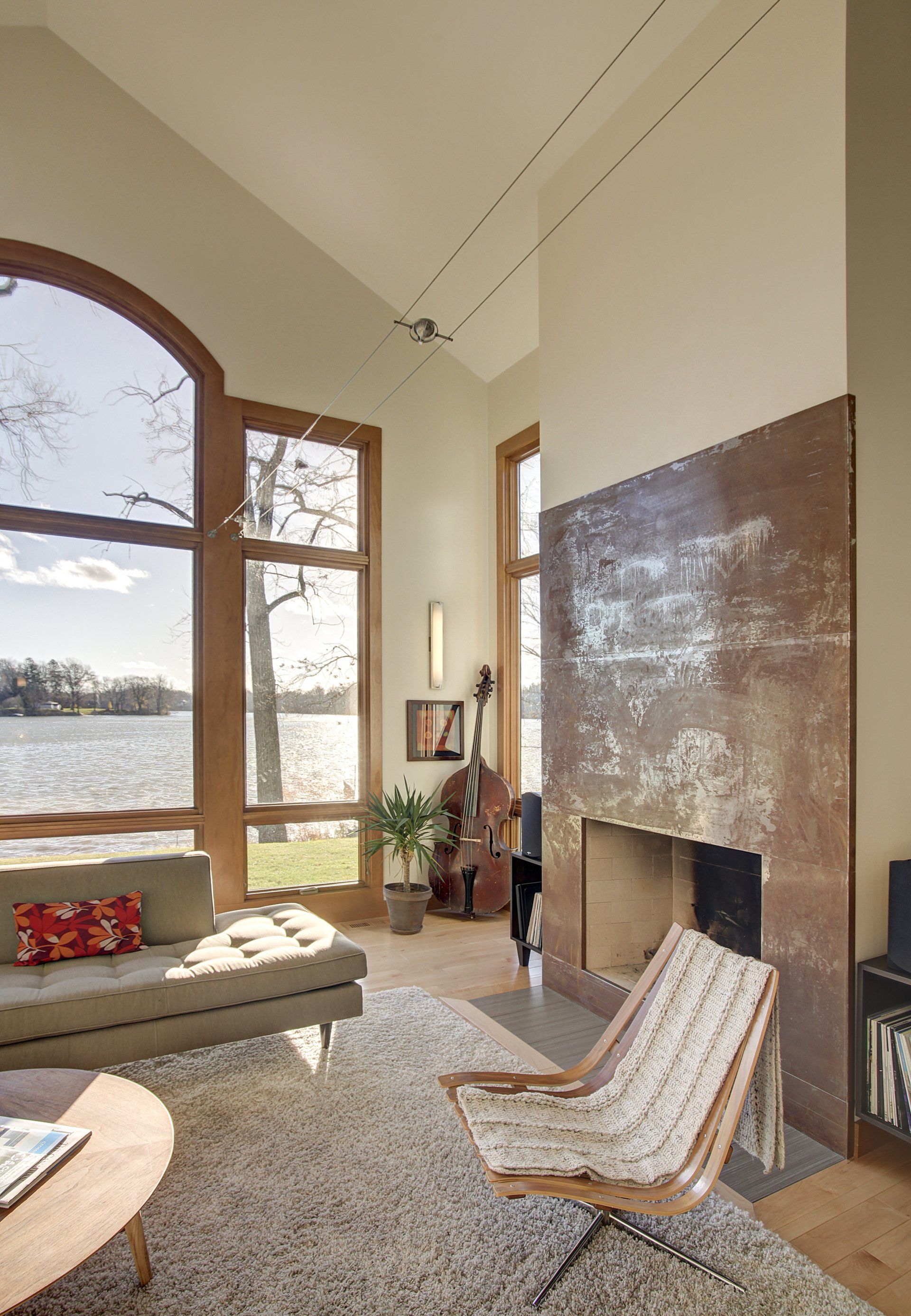 A living room with a fireplace and a view of a lake