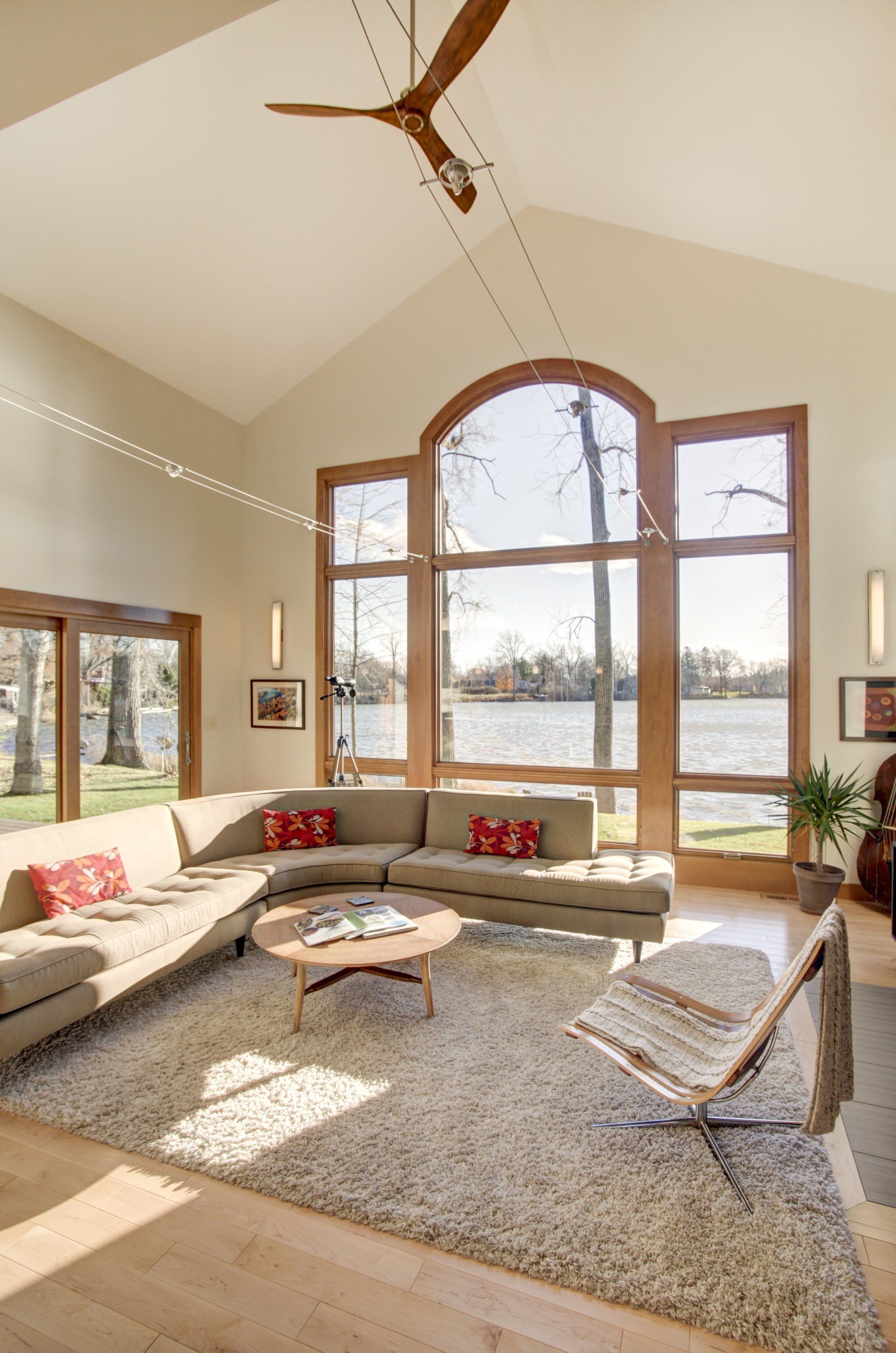 A living room with a lot of windows and a ceiling fan