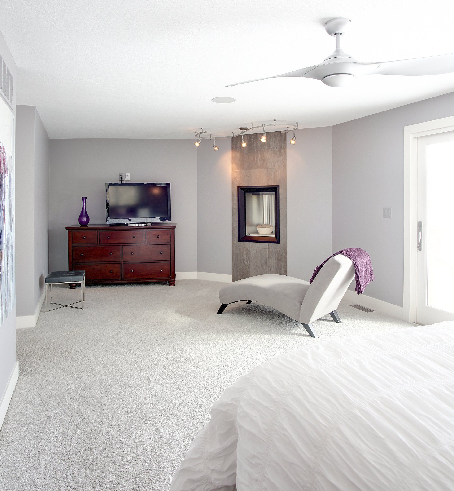 A bedroom with a bed a dresser and a television