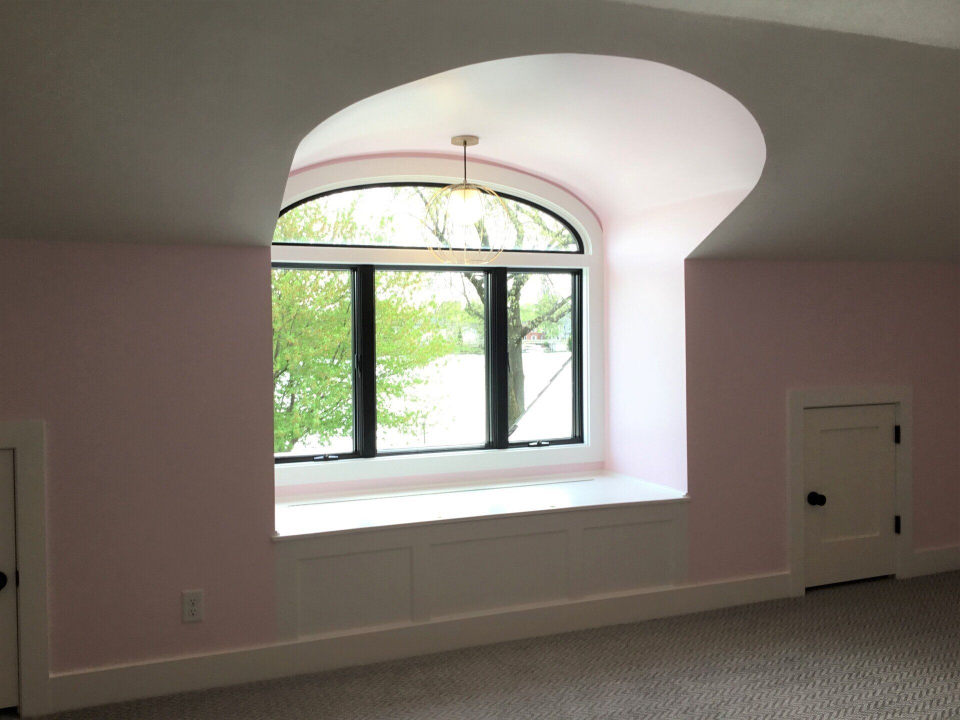 A room with pink walls and a large window
