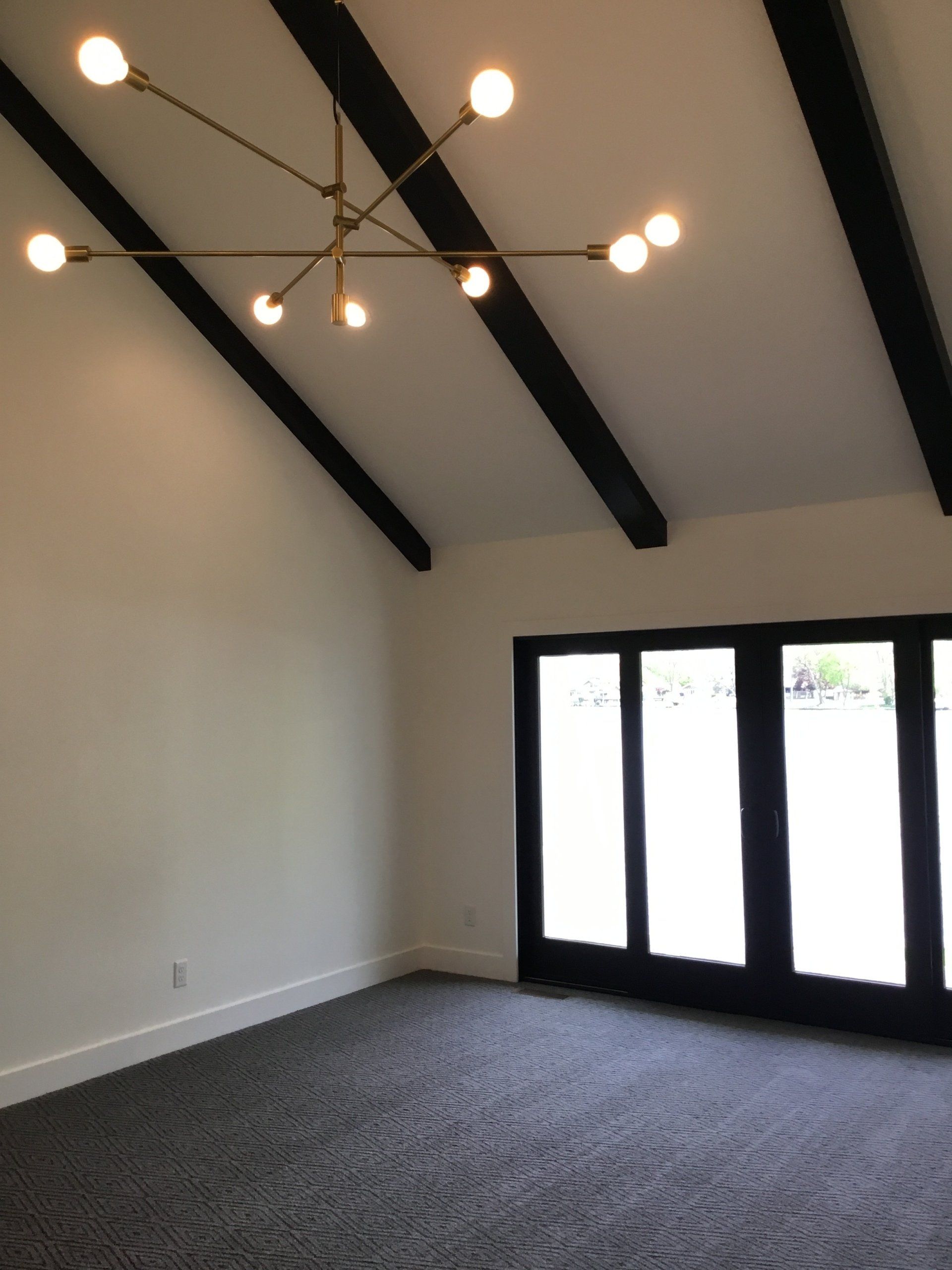 An empty room with a chandelier hanging from the ceiling