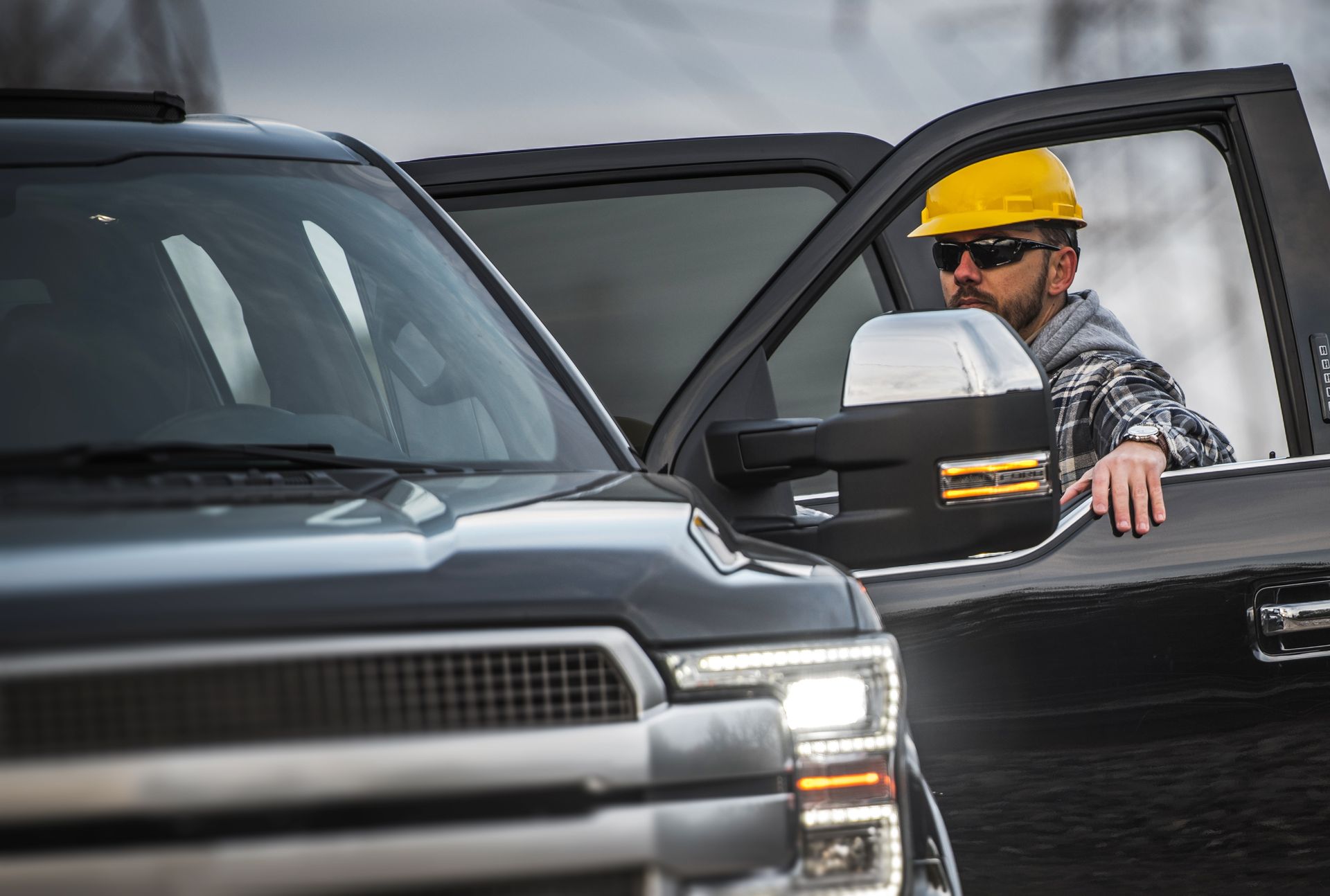 Construction worker showcasing stake beds with his corporate pickup truck at a worksite. Construction worker showcasing stake beds with his corporate pickup truck at a worksite.