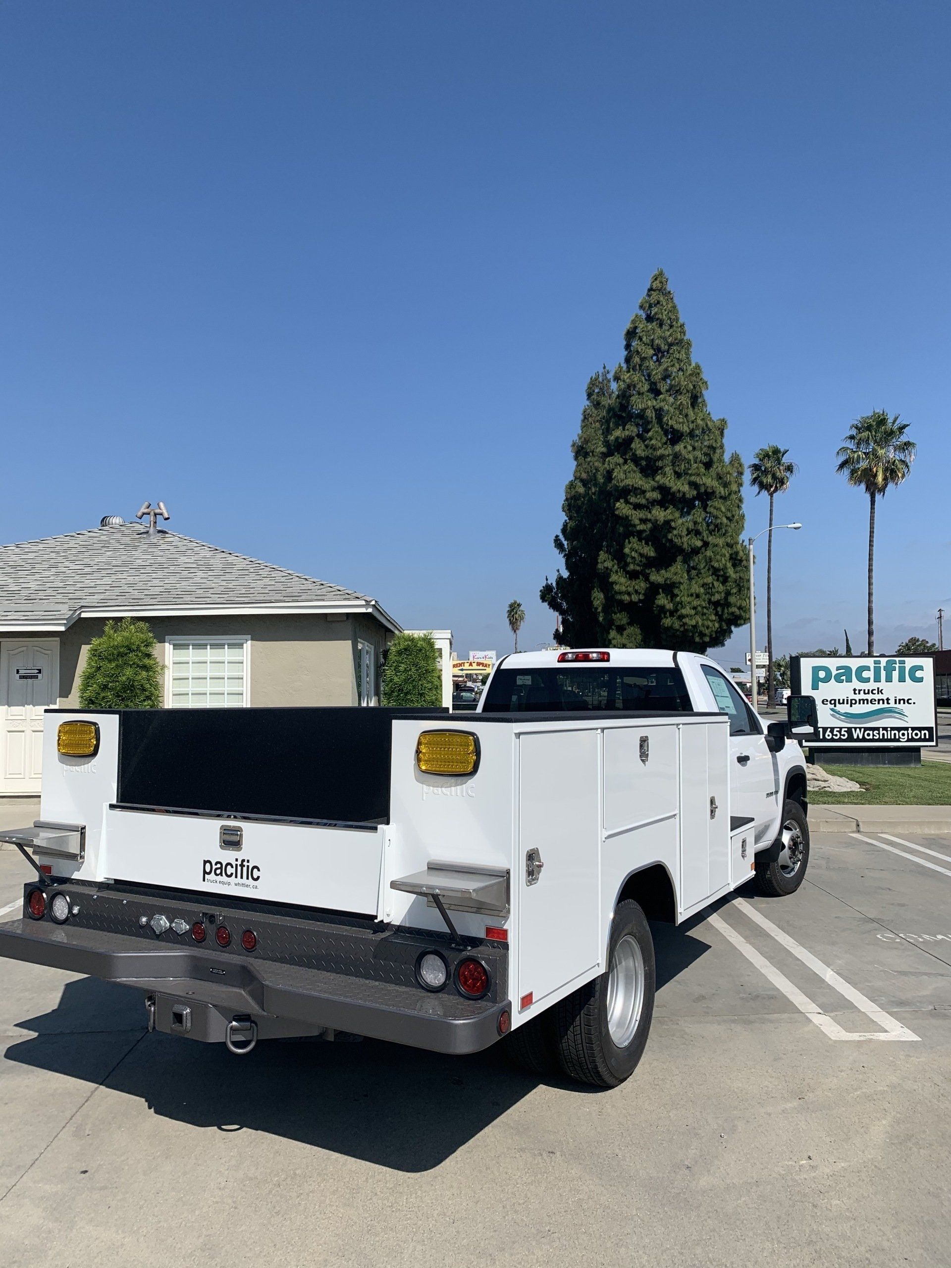 White utility truck parked outside, sunny day.