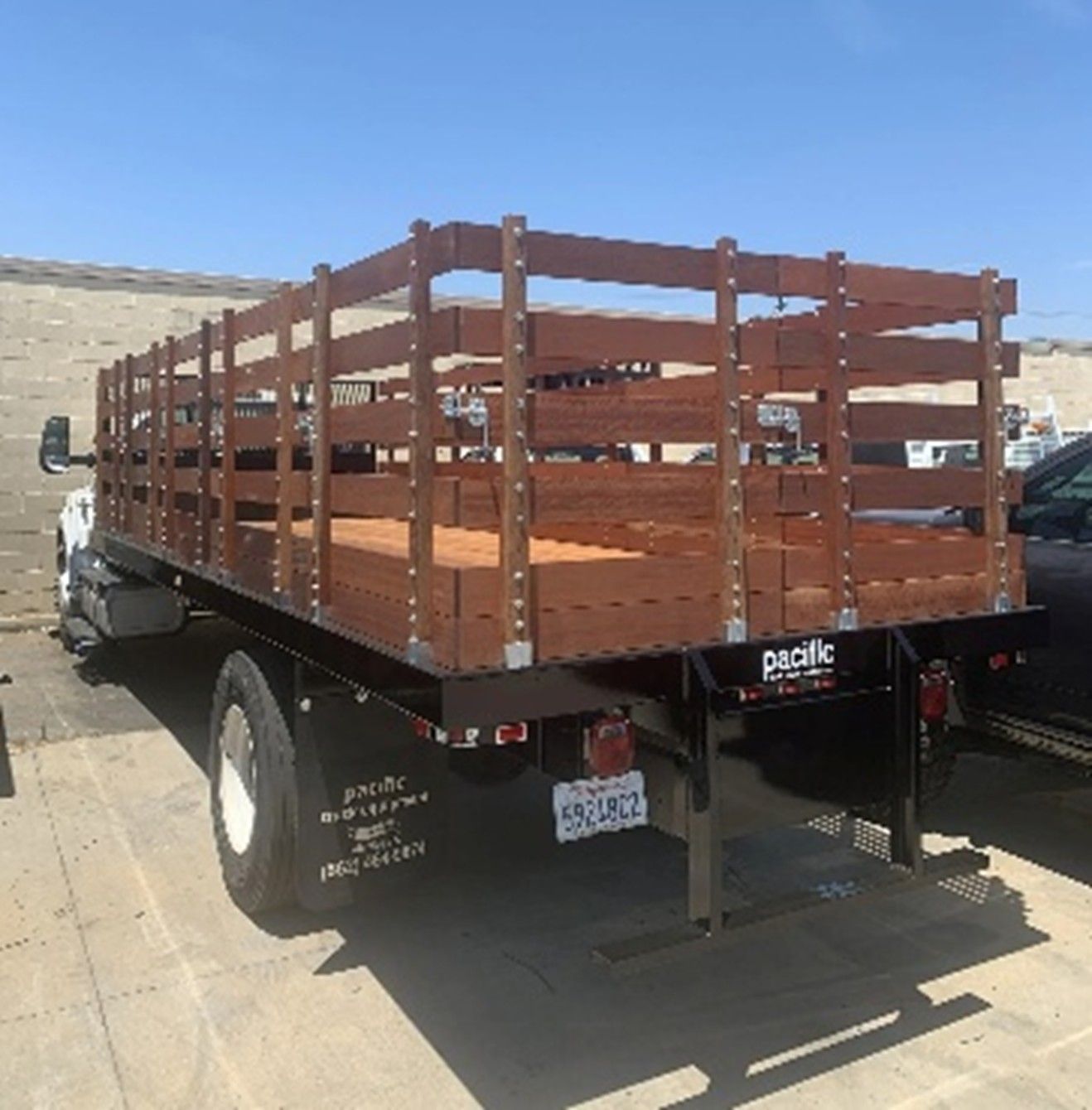 Stake bed truck with wooden sides.