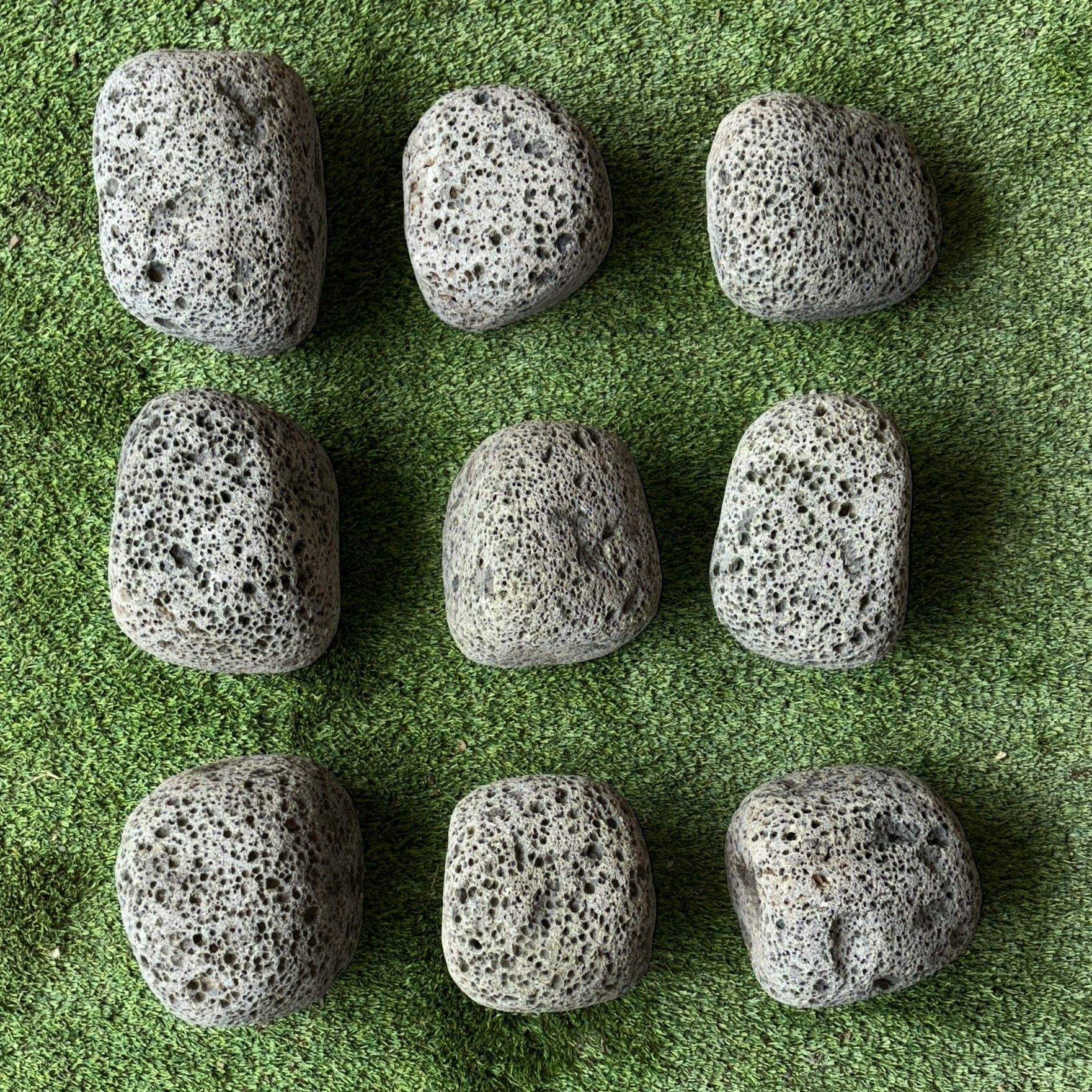 A group of rocks sitting on top of a lush green field.