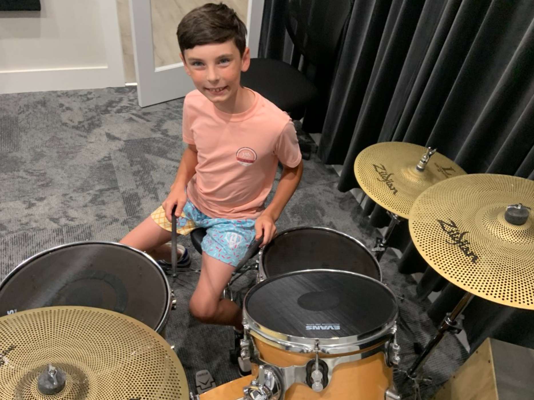A young girl is playing a violin in a room.