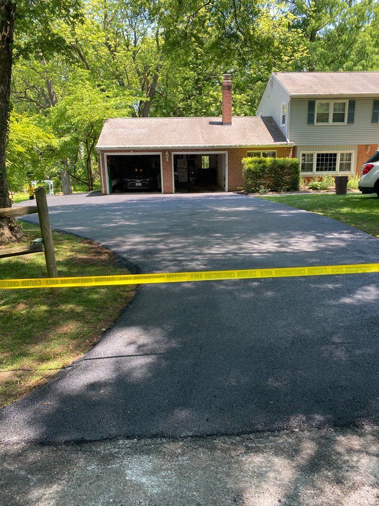 A driveway leading to a house with a yellow tape around it