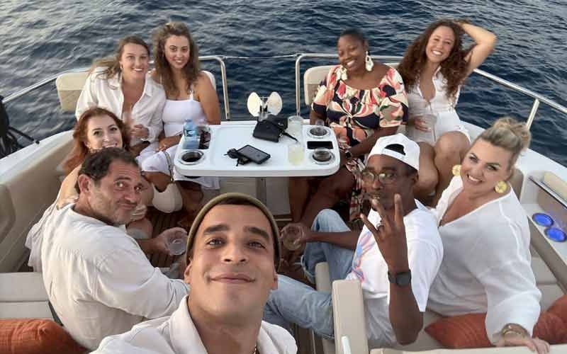 A family smiling while on the top of the boat