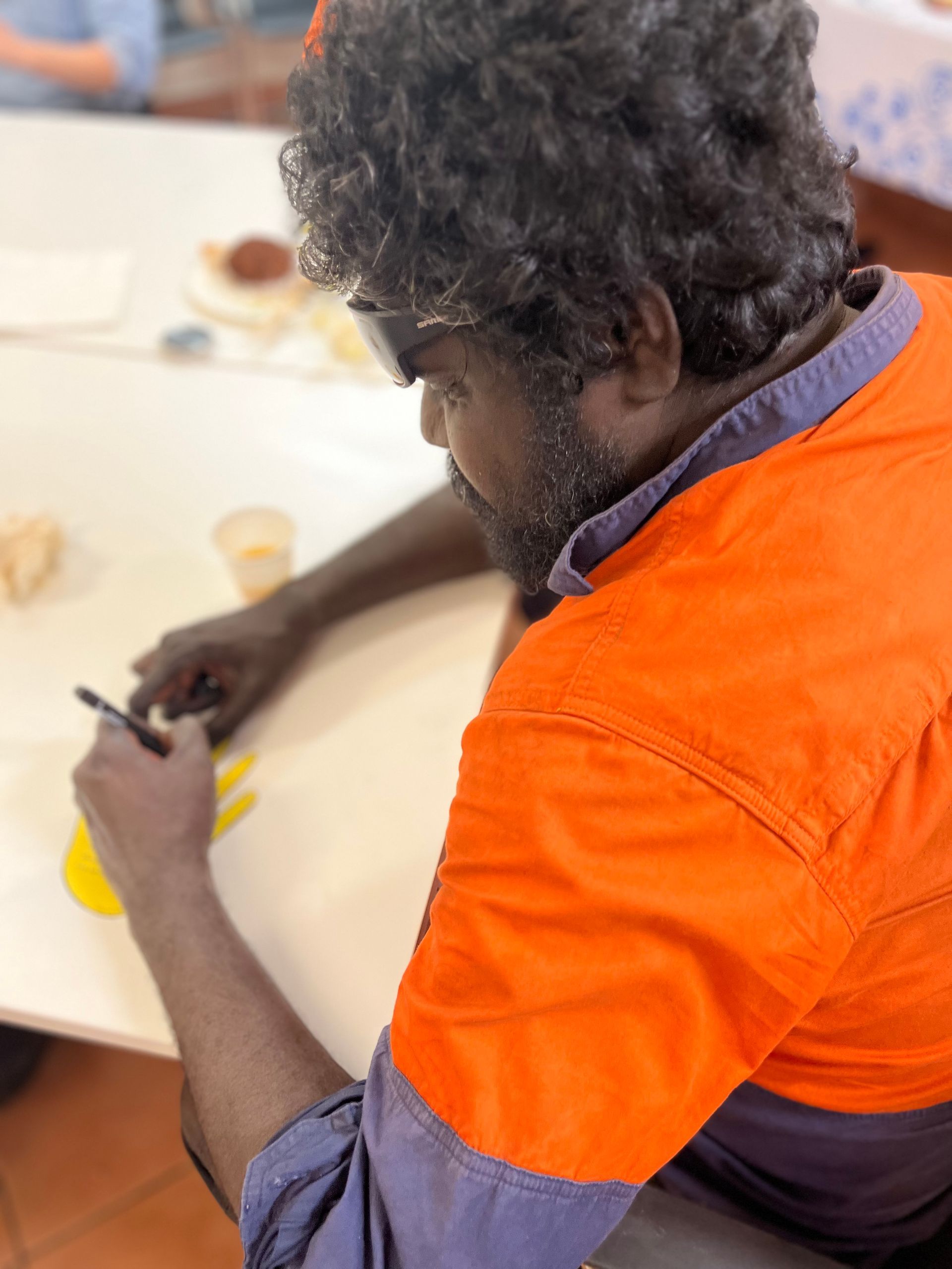 A man wearing a high vis shirt writing