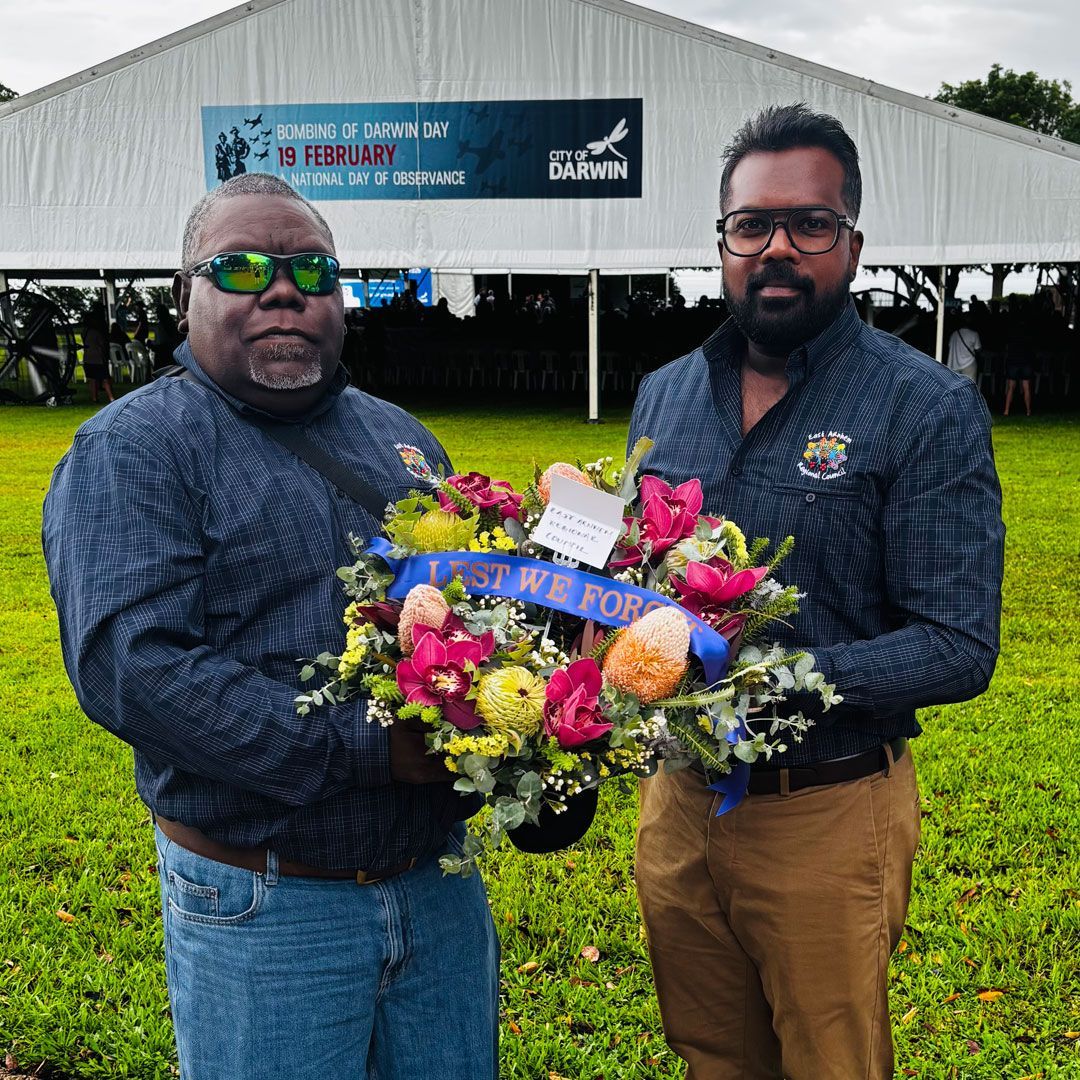 Two men holding a wreath at the memorial service for the 84th Anniversary of the Bombing of Darwin