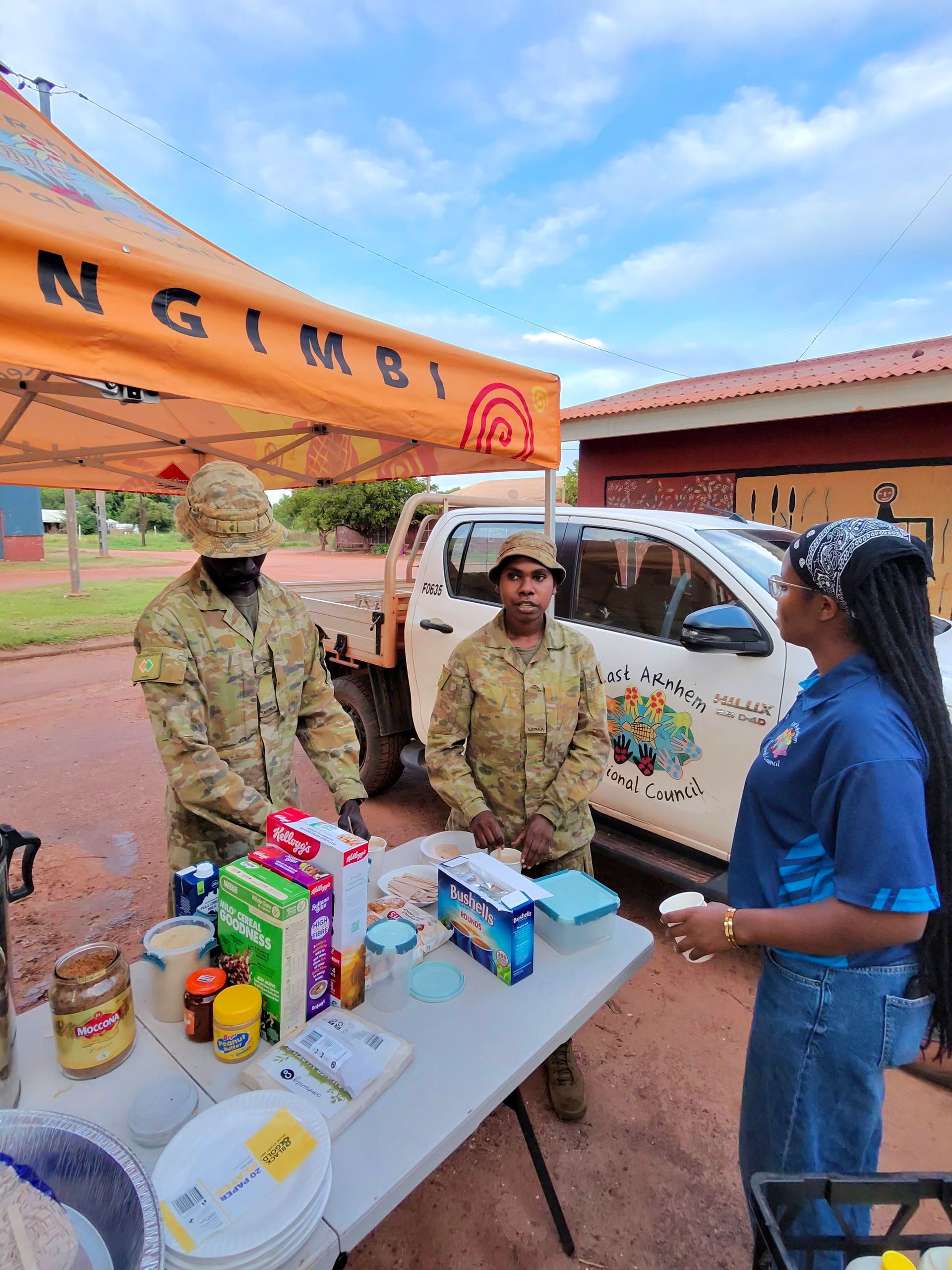 Three people stand around a table