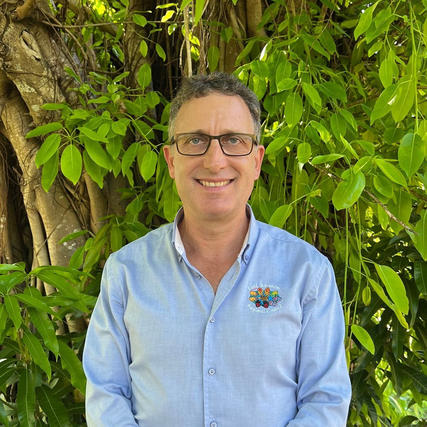 A man wearing glasses and a light blue shirt