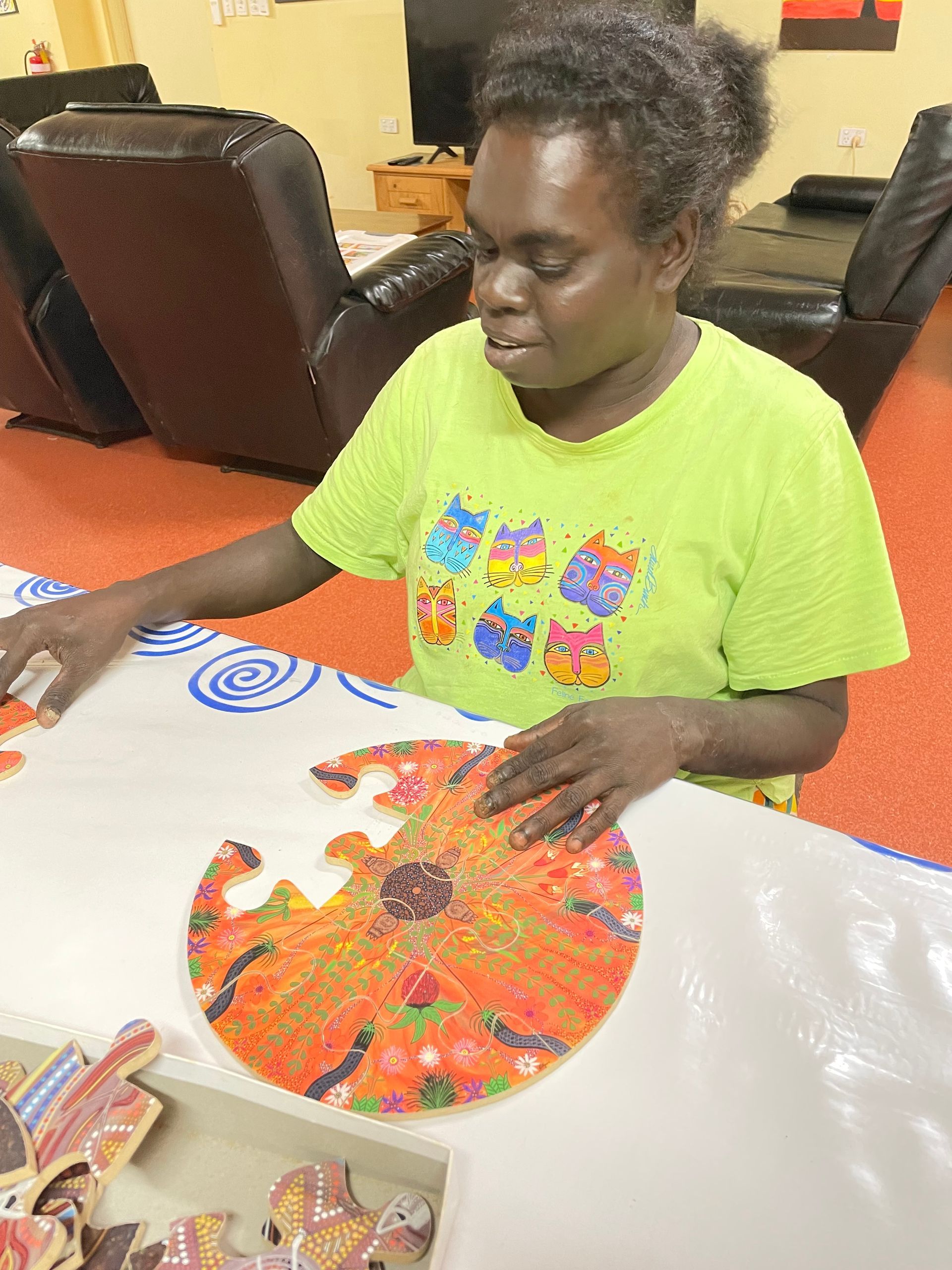 A woman works on a circular puzzle. 