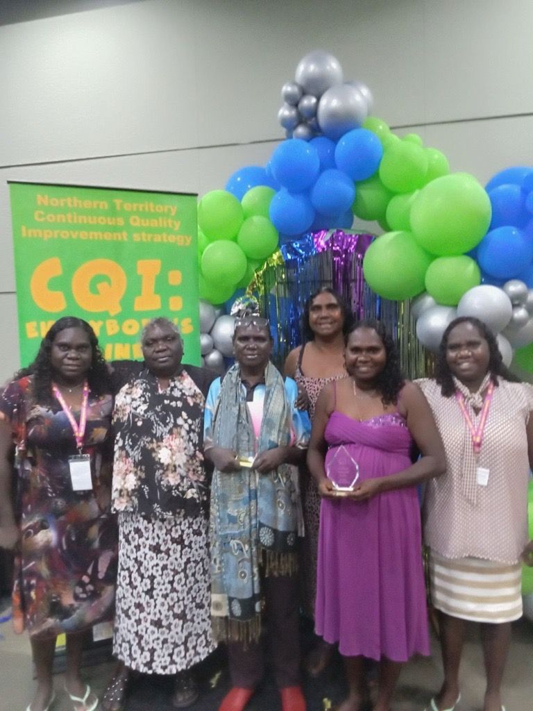 Six women standing together. Two in the middle are holding CQI awards