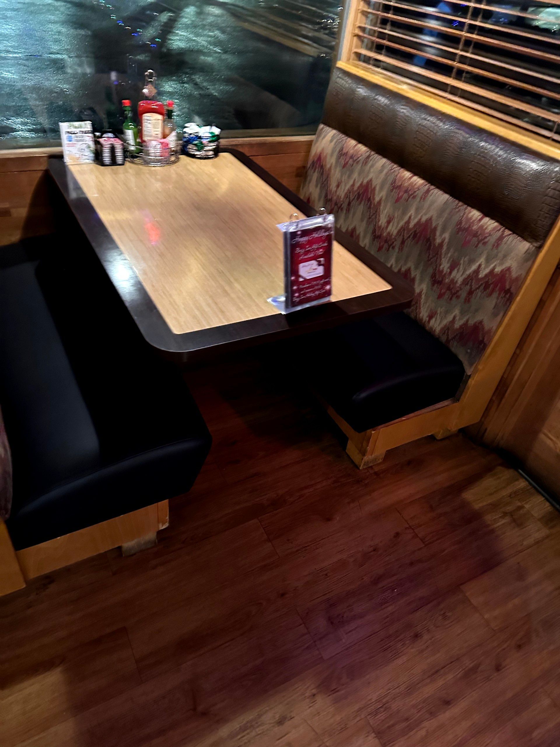 A restaurant booth with a table and a menu on it