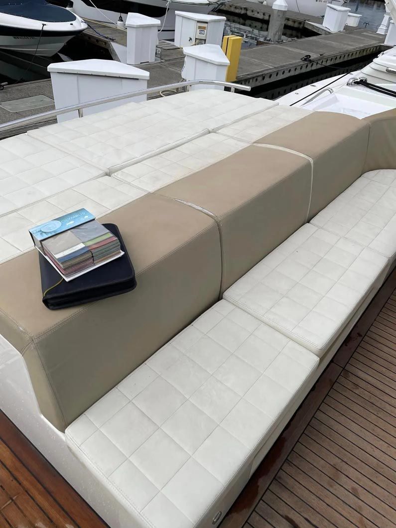 A couch is sitting on top of a wooden deck next to a dock.