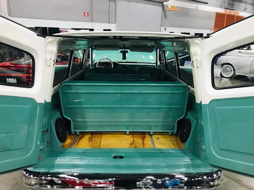 The back of a green and white station wagon with its doors open.