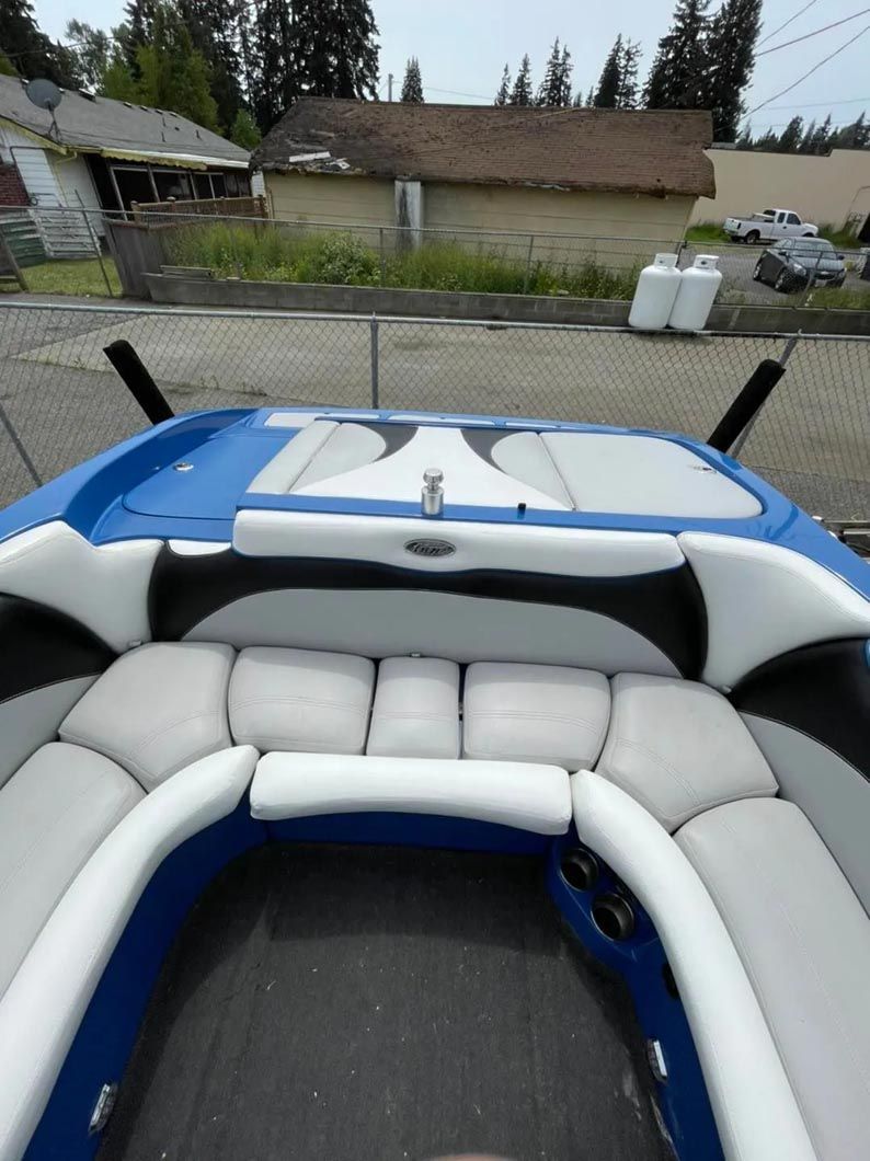 A blue and white boat is parked in front of a house