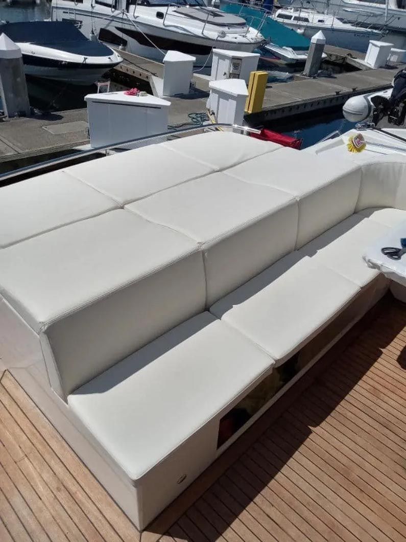 A white couch is sitting on the deck of a boat.