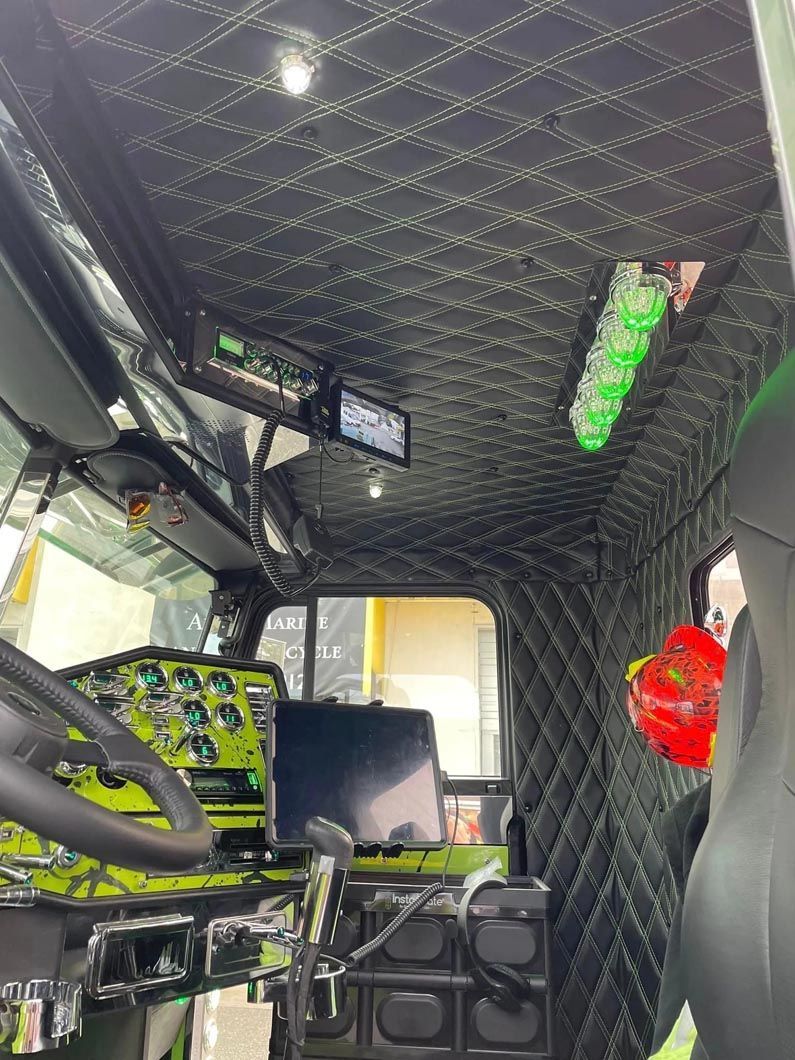 The inside of a truck with a steering wheel and a dashboard.