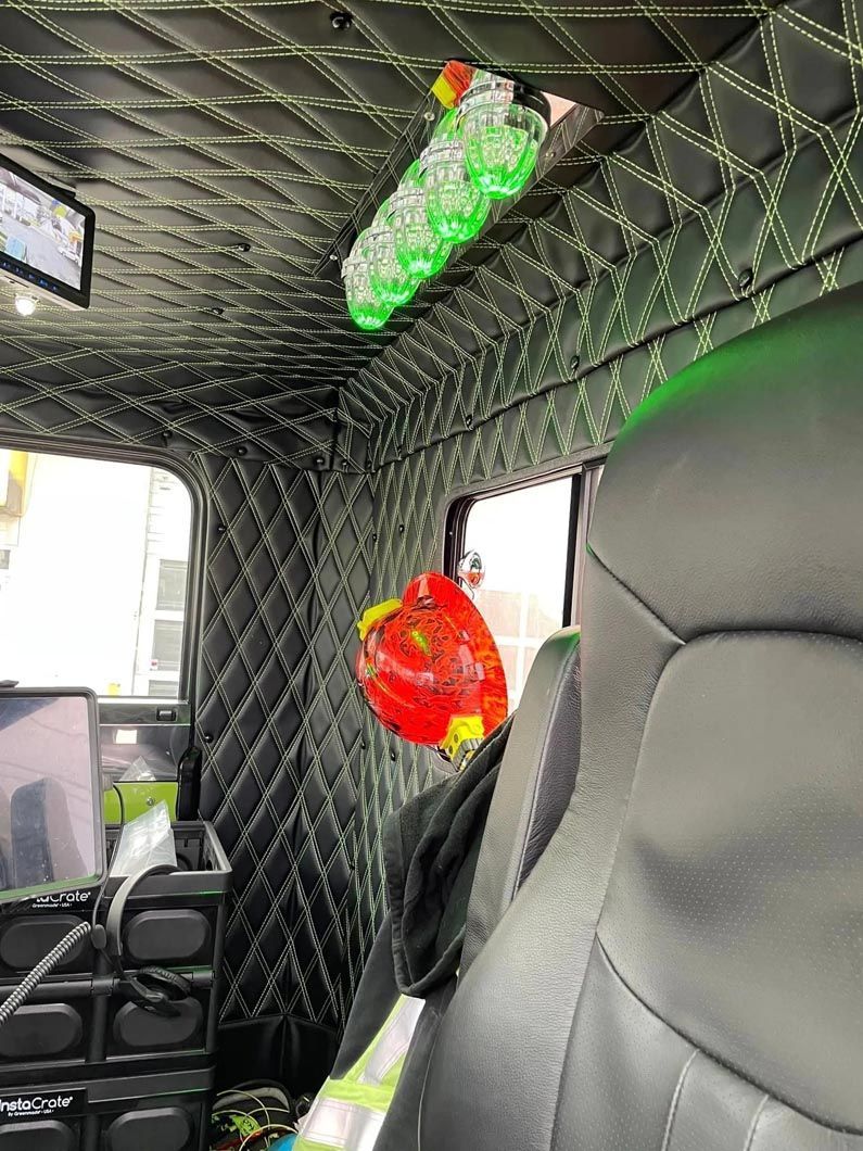 The inside of a car with a green bottle hanging from the ceiling.
