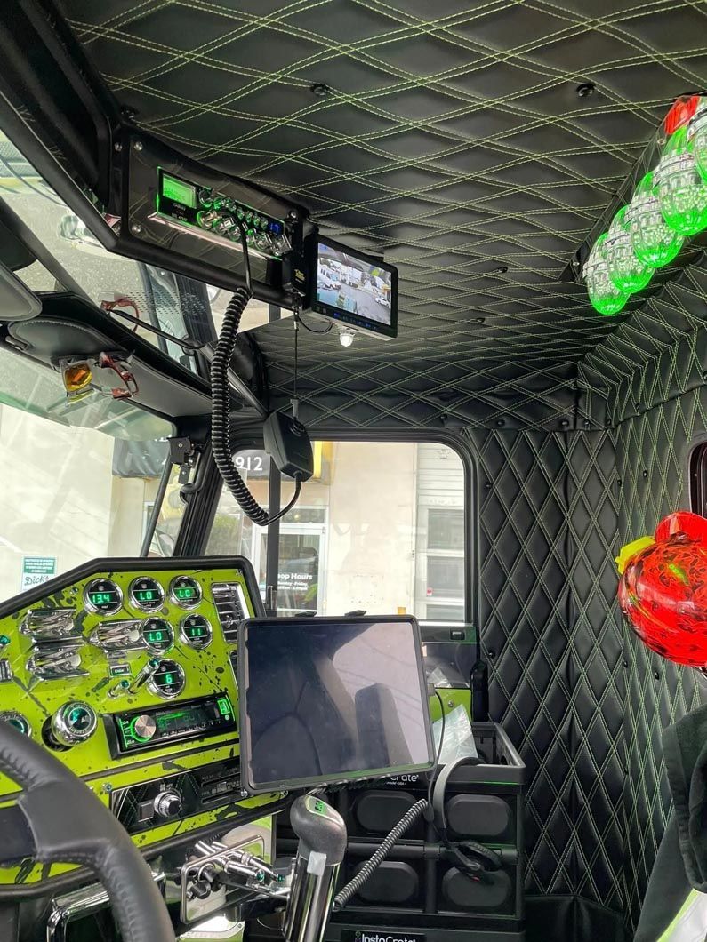 The inside of a truck with a dashboard and a monitor.