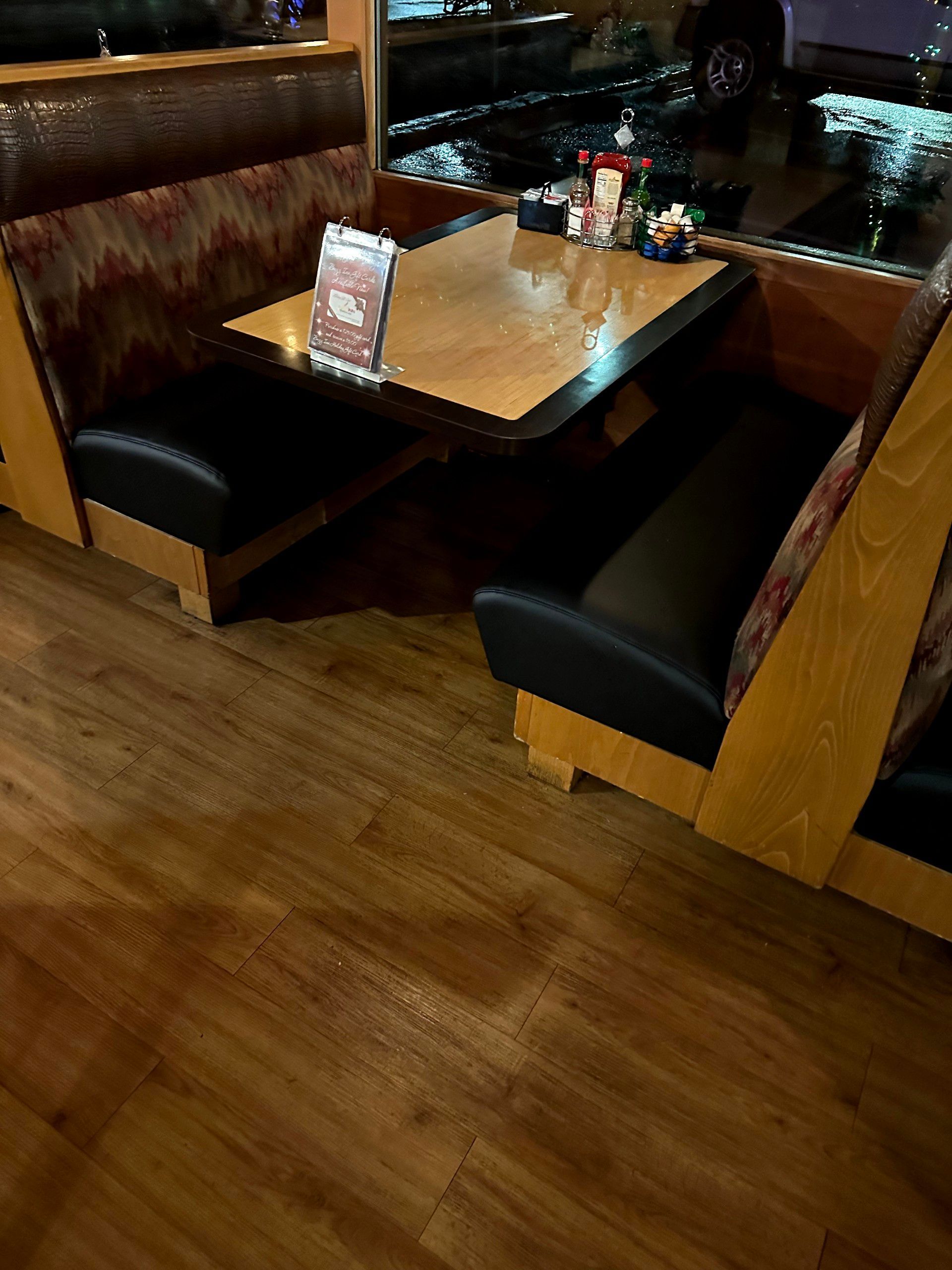 A restaurant booth with a table and chairs in it.