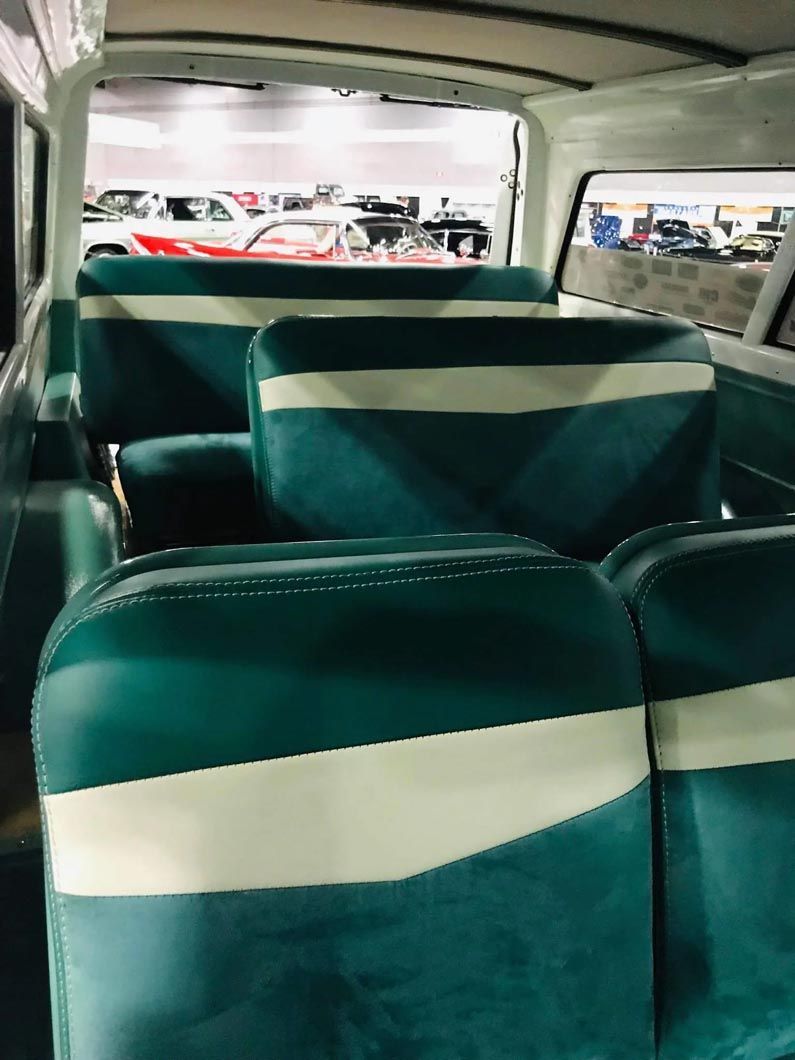 The inside of a van with green and white seats.