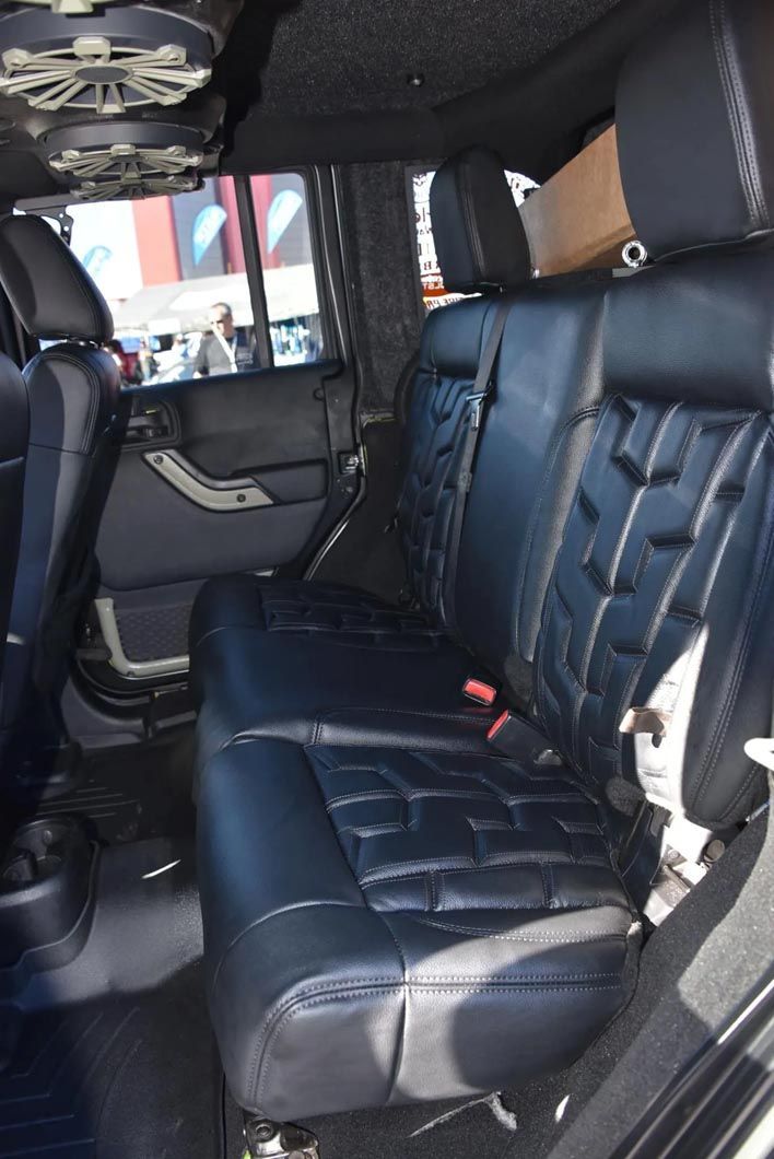 The back seat of a jeep wrangler with black leather seats.