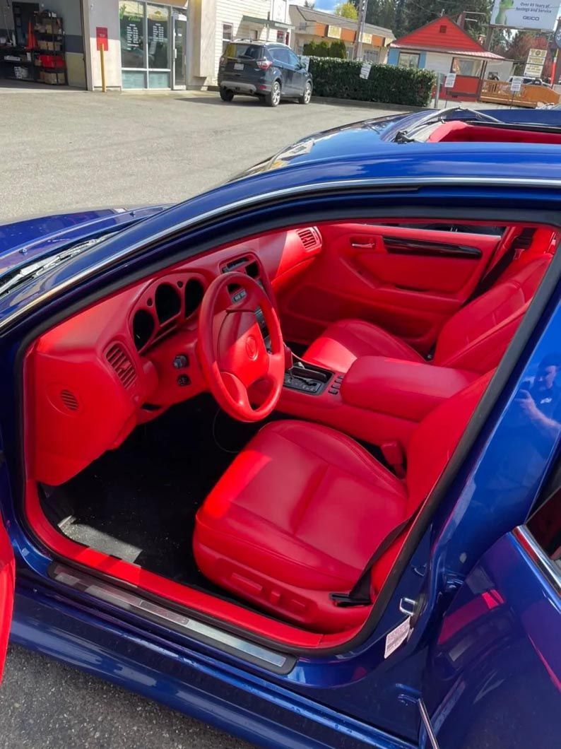The inside of a blue car with red seats